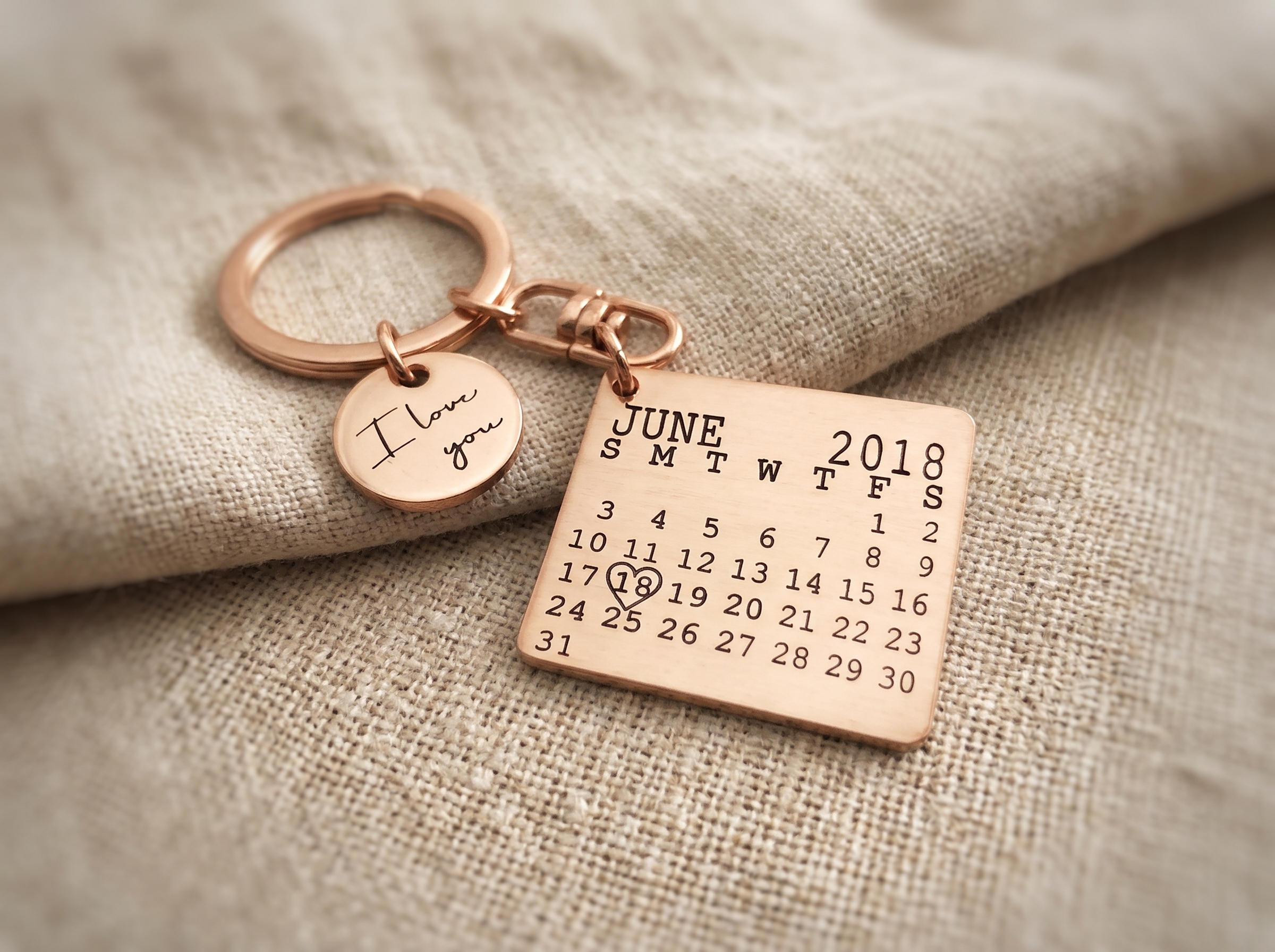 A single engraved keyring on a set of keys beside an unpacked moving box