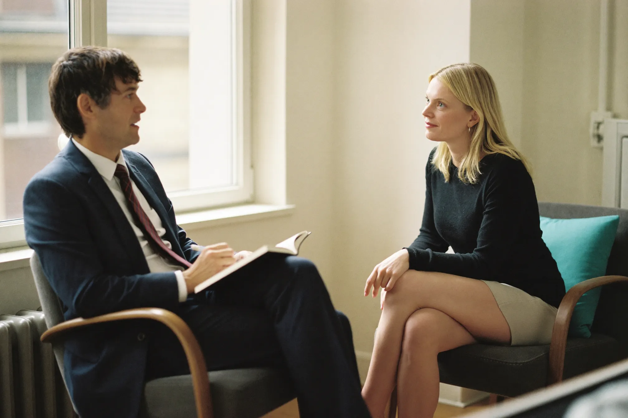 Séance de coaching : un manager et un consultant en conversation dans un coin calme et lumineux