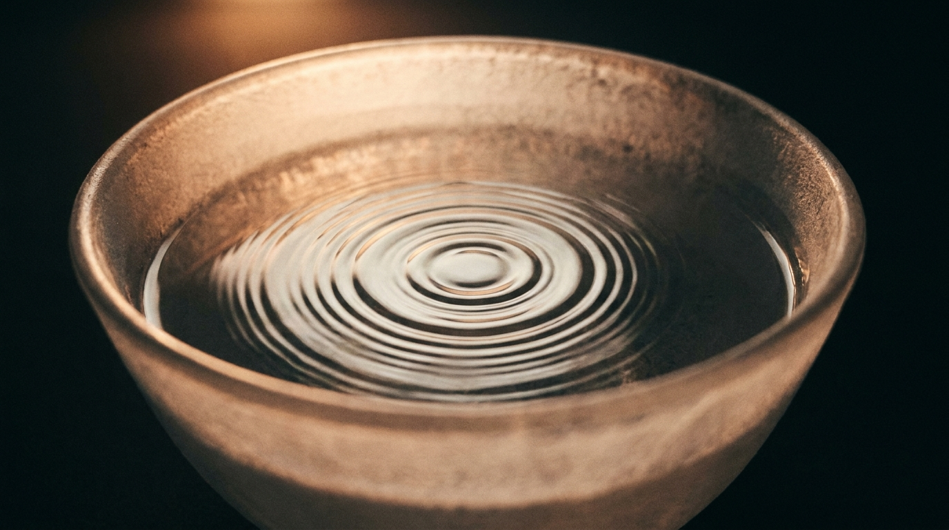 Standing wave ripples on the surface of water inside a crystal singing bowl