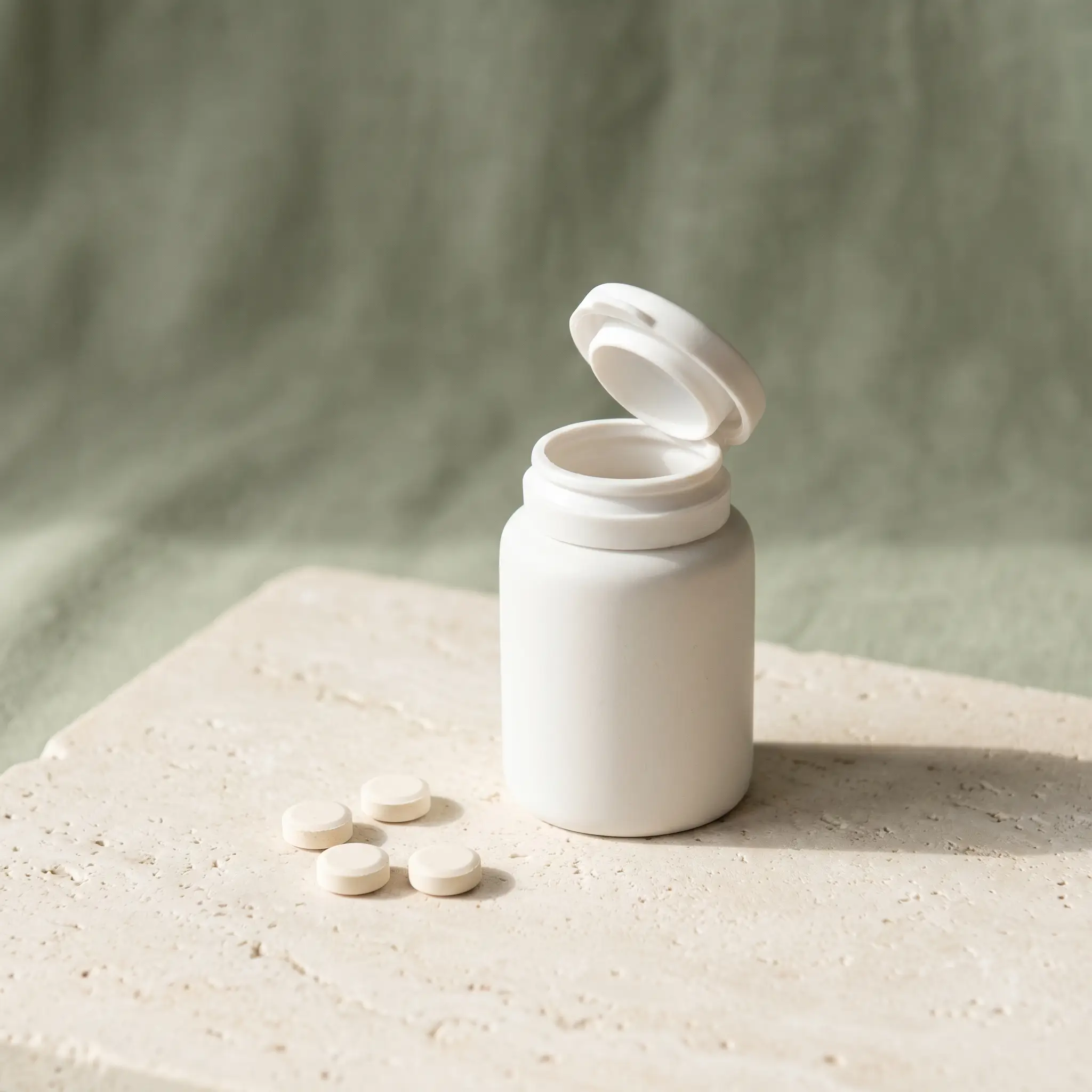 Minimalist studio photograph of a small pill bottle, representing prescription anti-nausea support