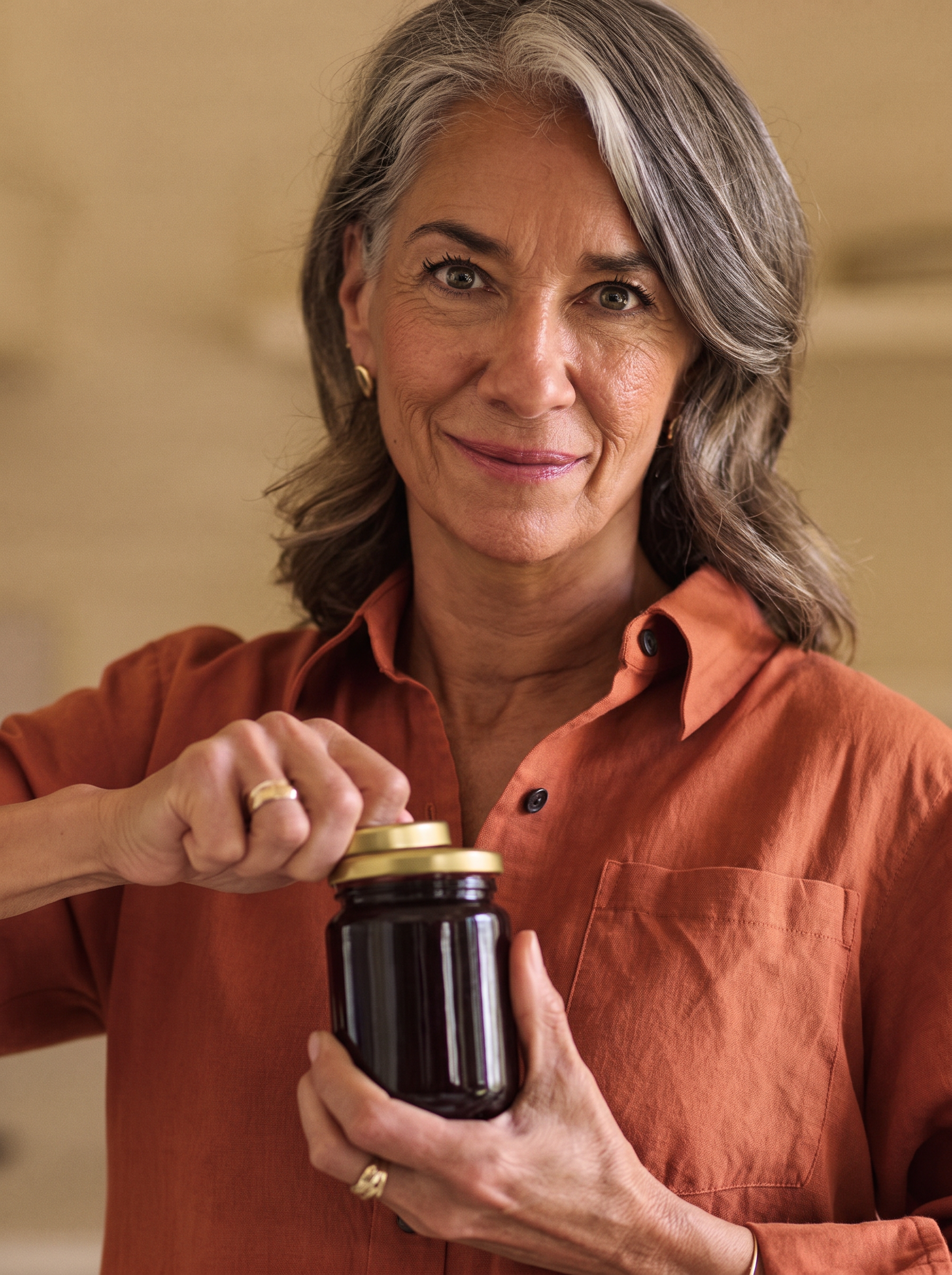 A woman opening a jar easily in her kitchen