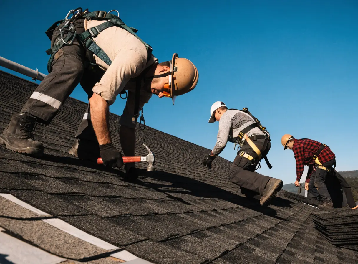 Roofing crew installing shingles on a residential roof