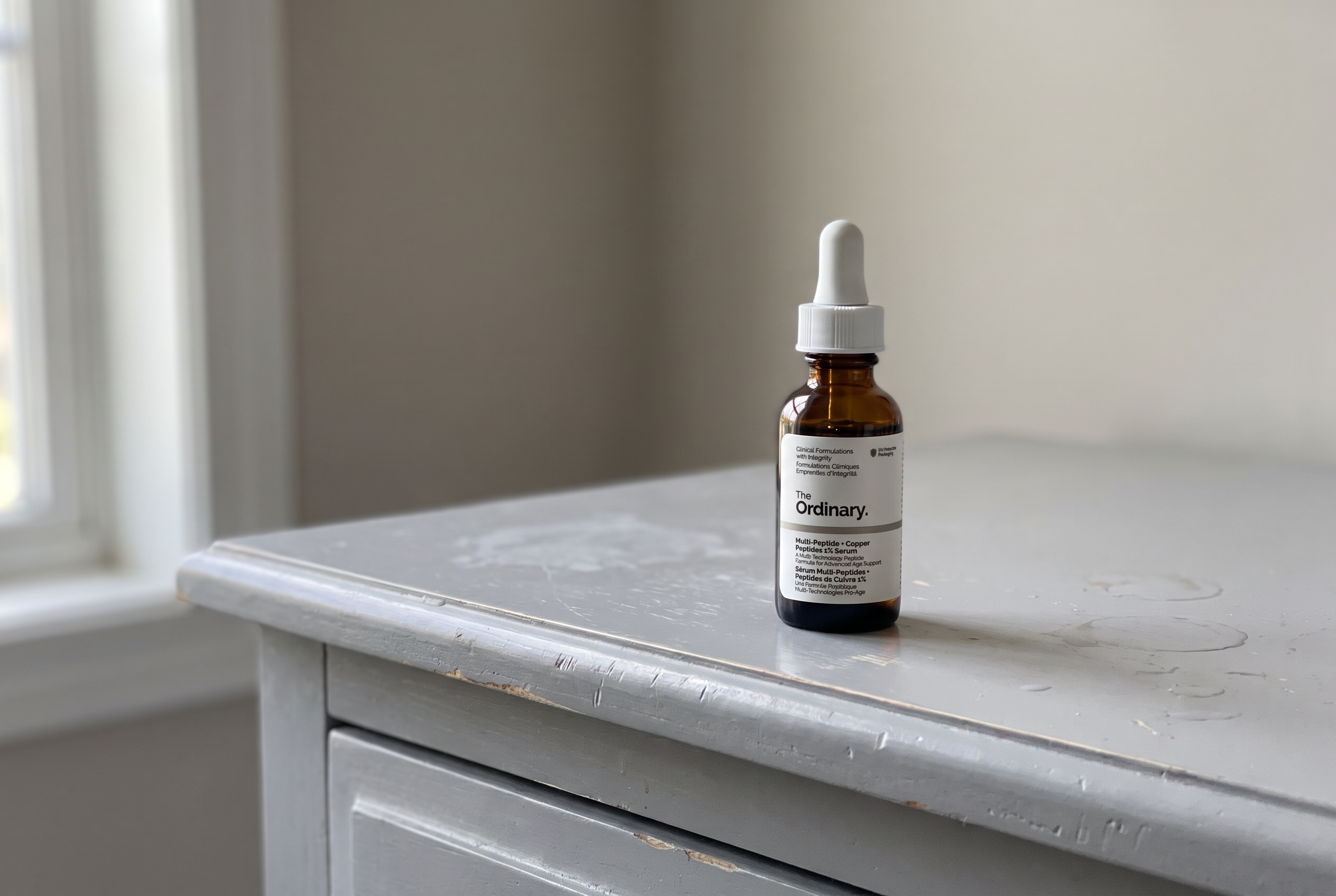 The Ordinary Multi-Peptide and Copper Peptides 1% bottle on a bathroom vanity