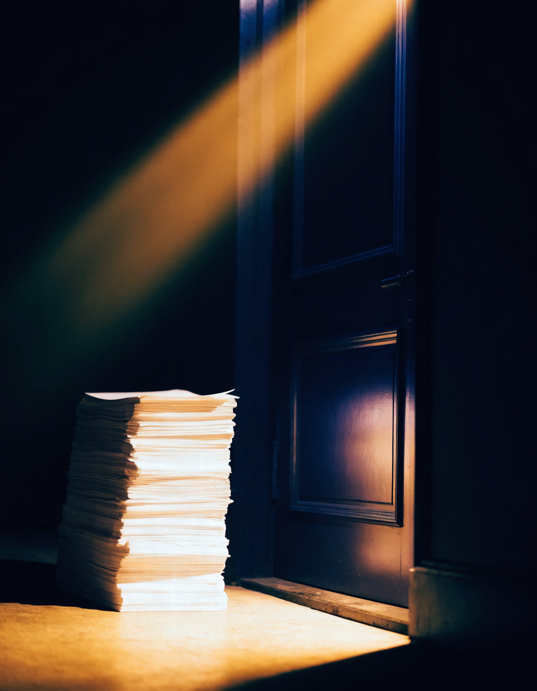 A stack of paper beside a closed restaurant door at night