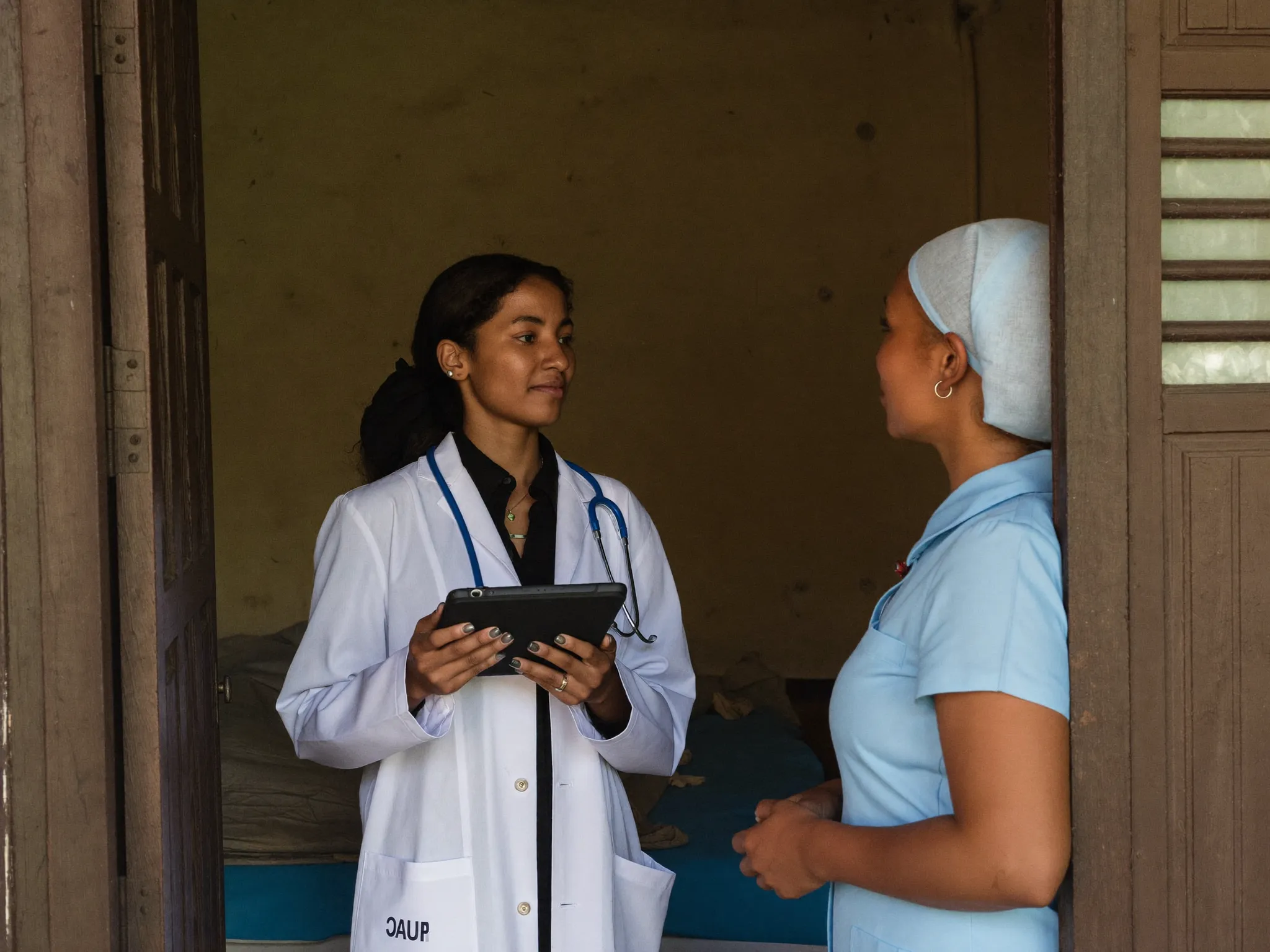 Researcher with a tablet talking with a nurse at a rural health clinic