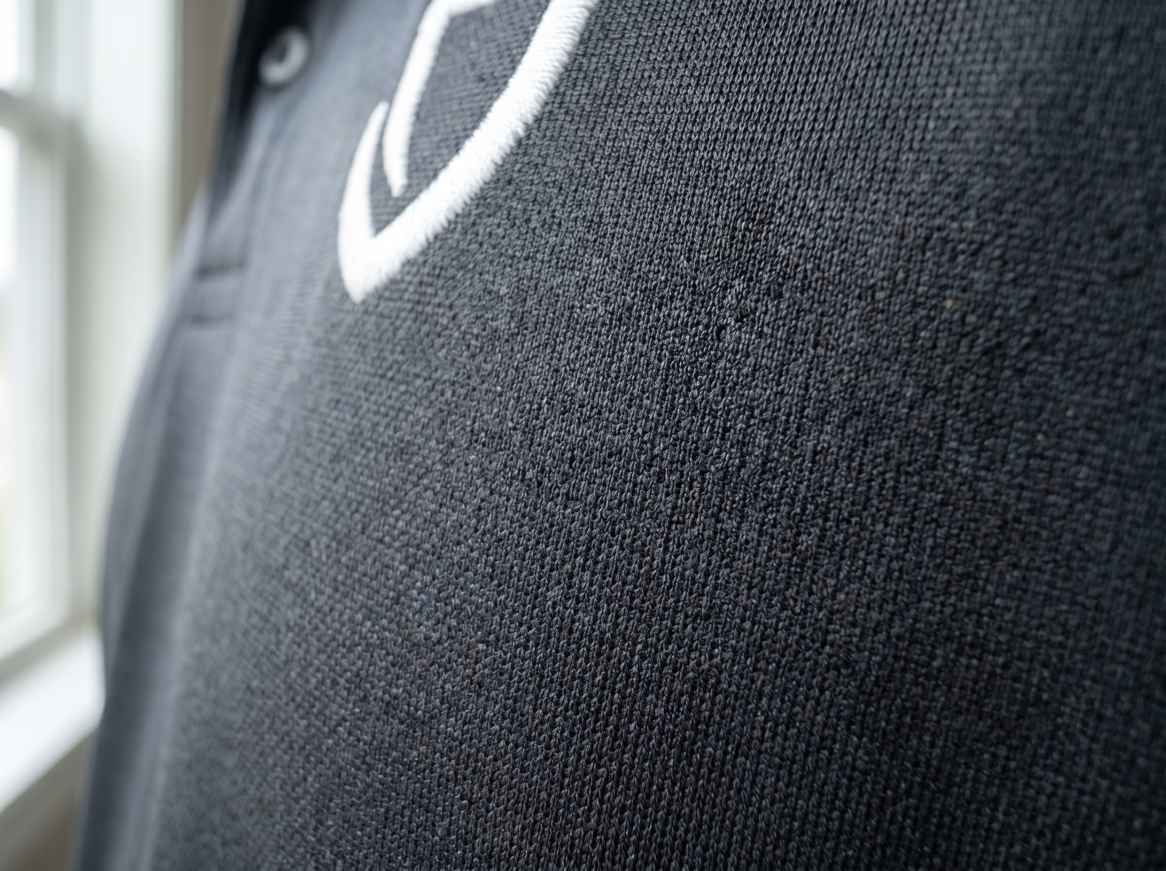 Performance moisture-wicking polo fabric close-up - athletic stretch material for golf and sports uniforms