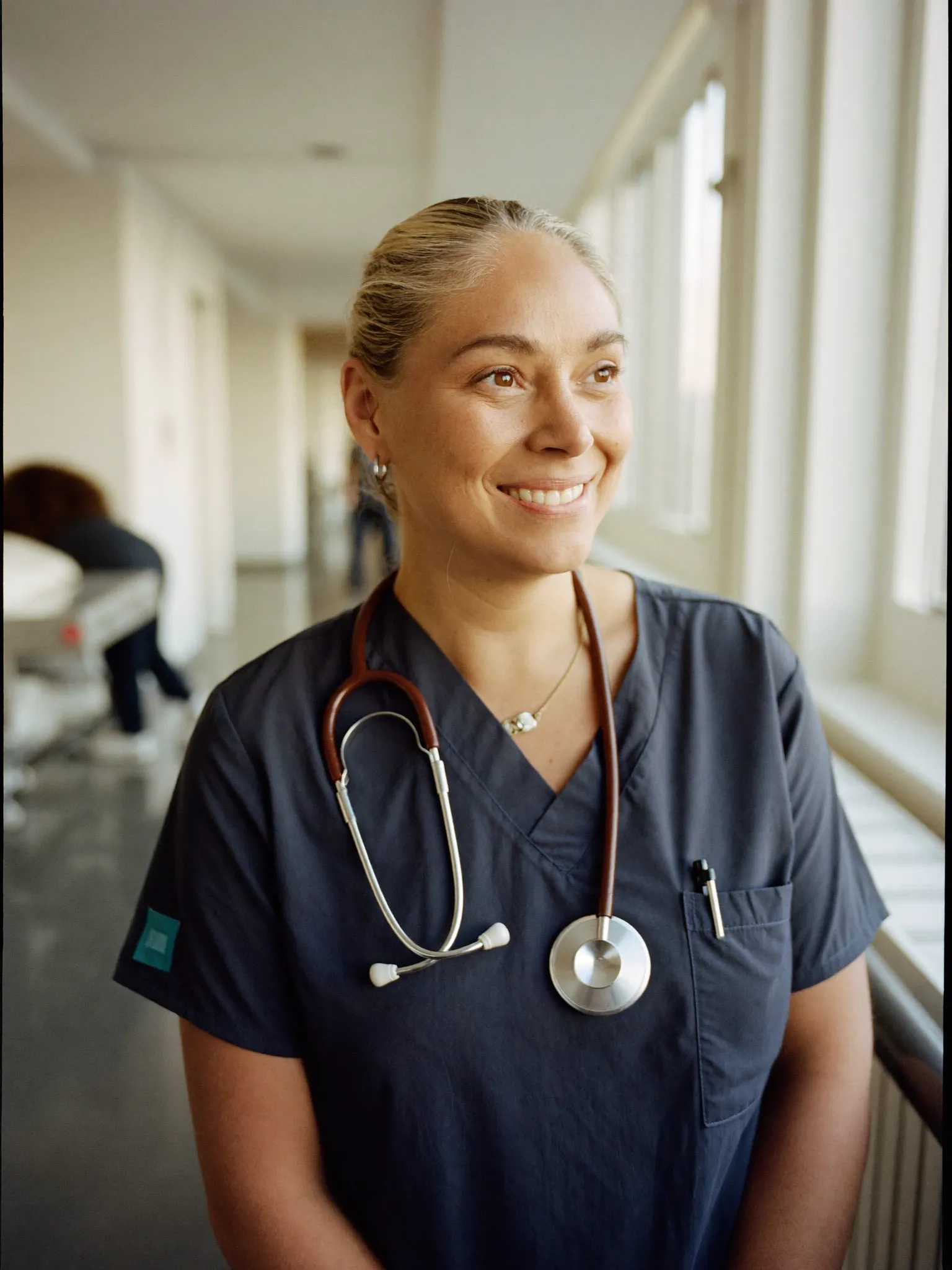 Nurse in scrubs in a hospital corridor