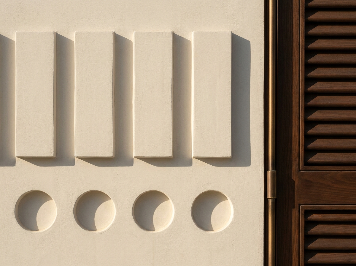 Coral limestone mass with bronze-finish screen — the 1/0 grammar at facade scale