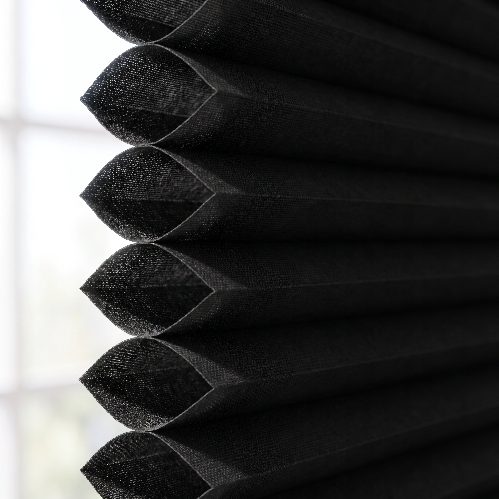 Macro close-up of the matte black double-cell honeycomb structure of the shade, showing the air pockets.
