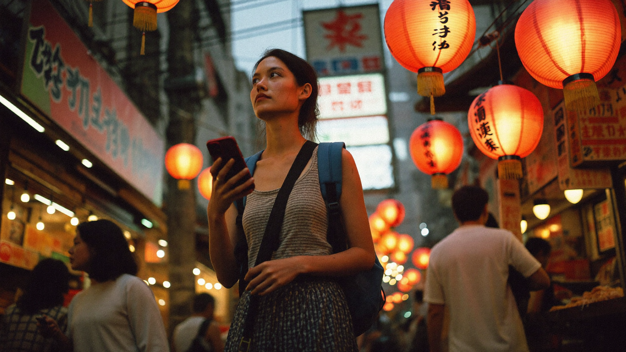 Solo traveller navigating a busy Tokyo street market, phone in hand, vibrant lanterns overhead
