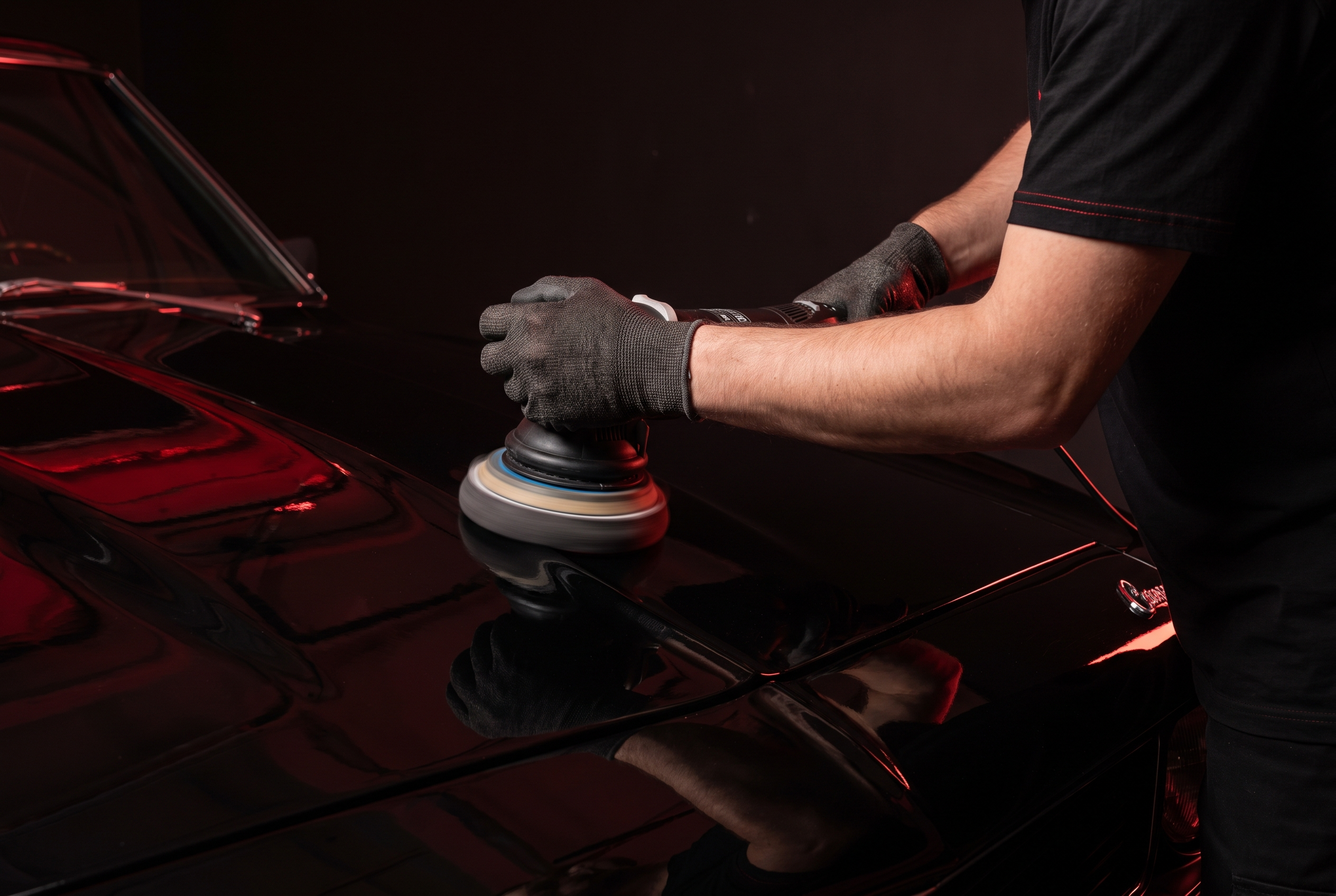 Polisher correcting glossy black paint before ceramic