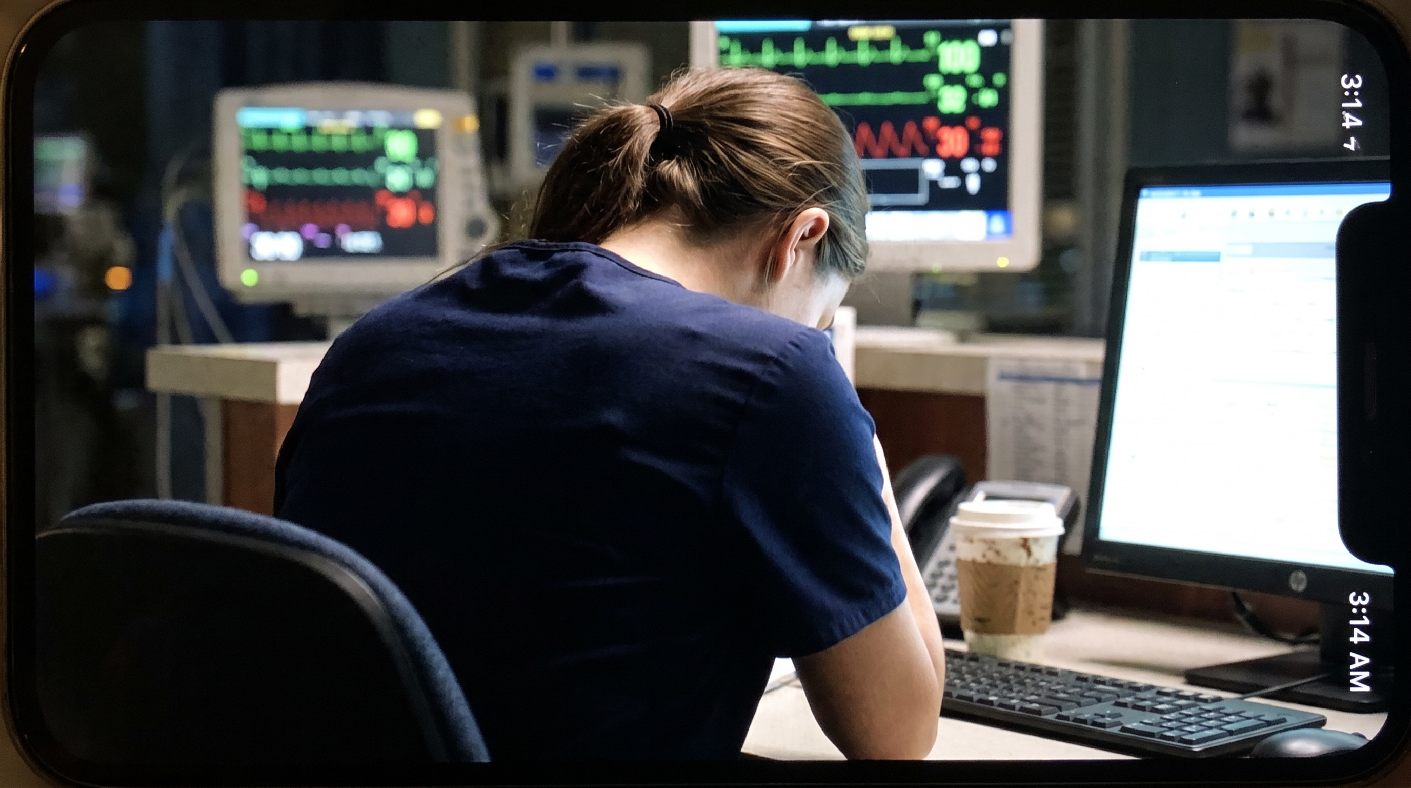 New nurse charting alone in a dim ICU at night