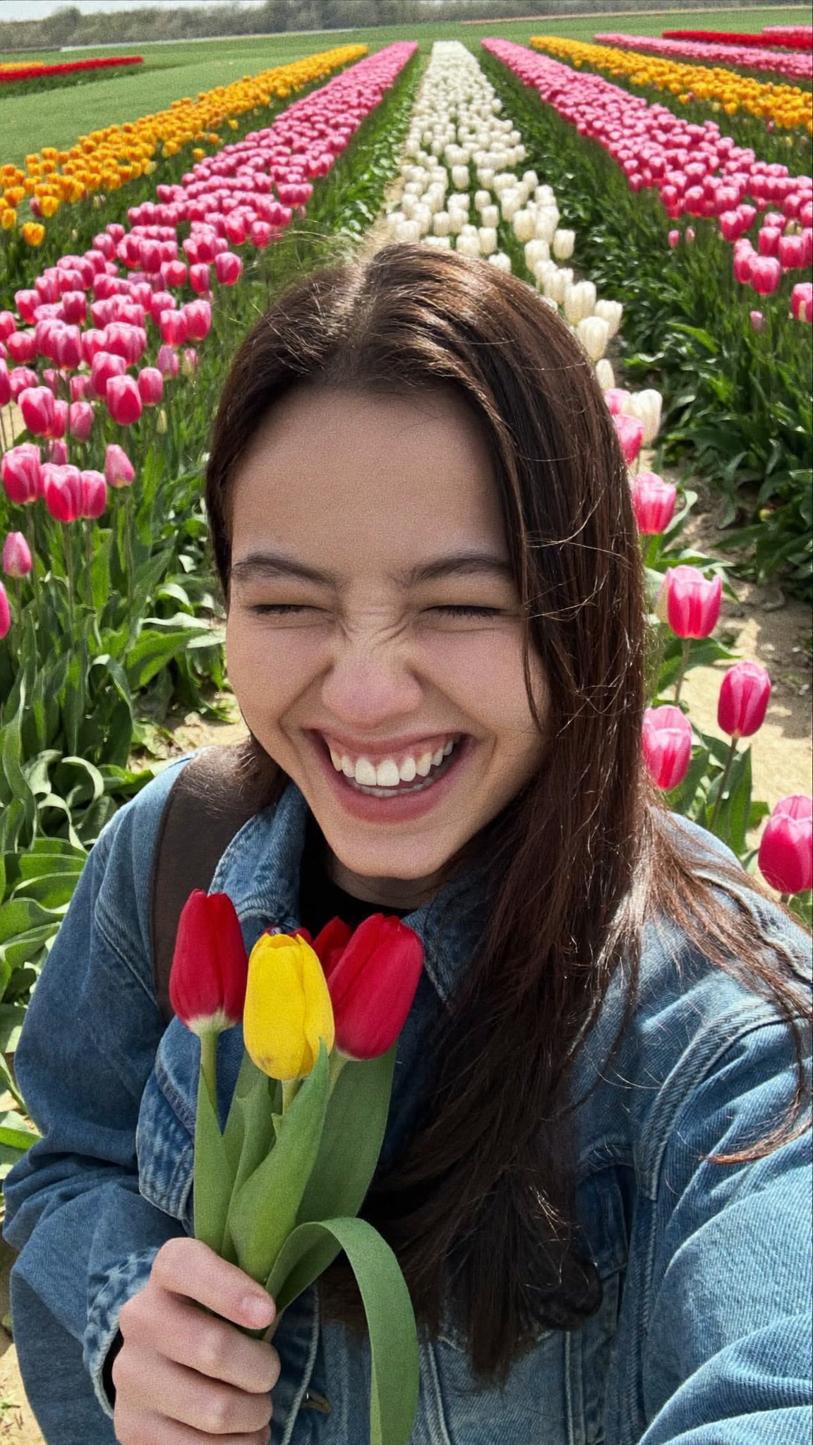 A woman filming herself at a spring tulip farm