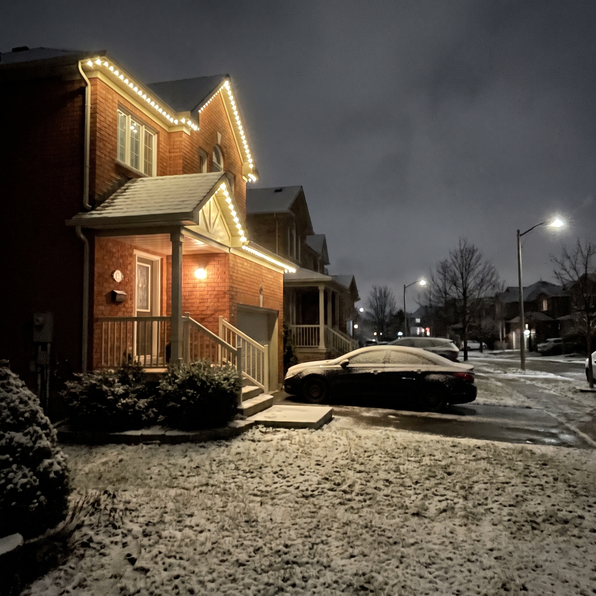 Permanent LED roofline lighting glowing warm white on a red-brick two-storey home at night