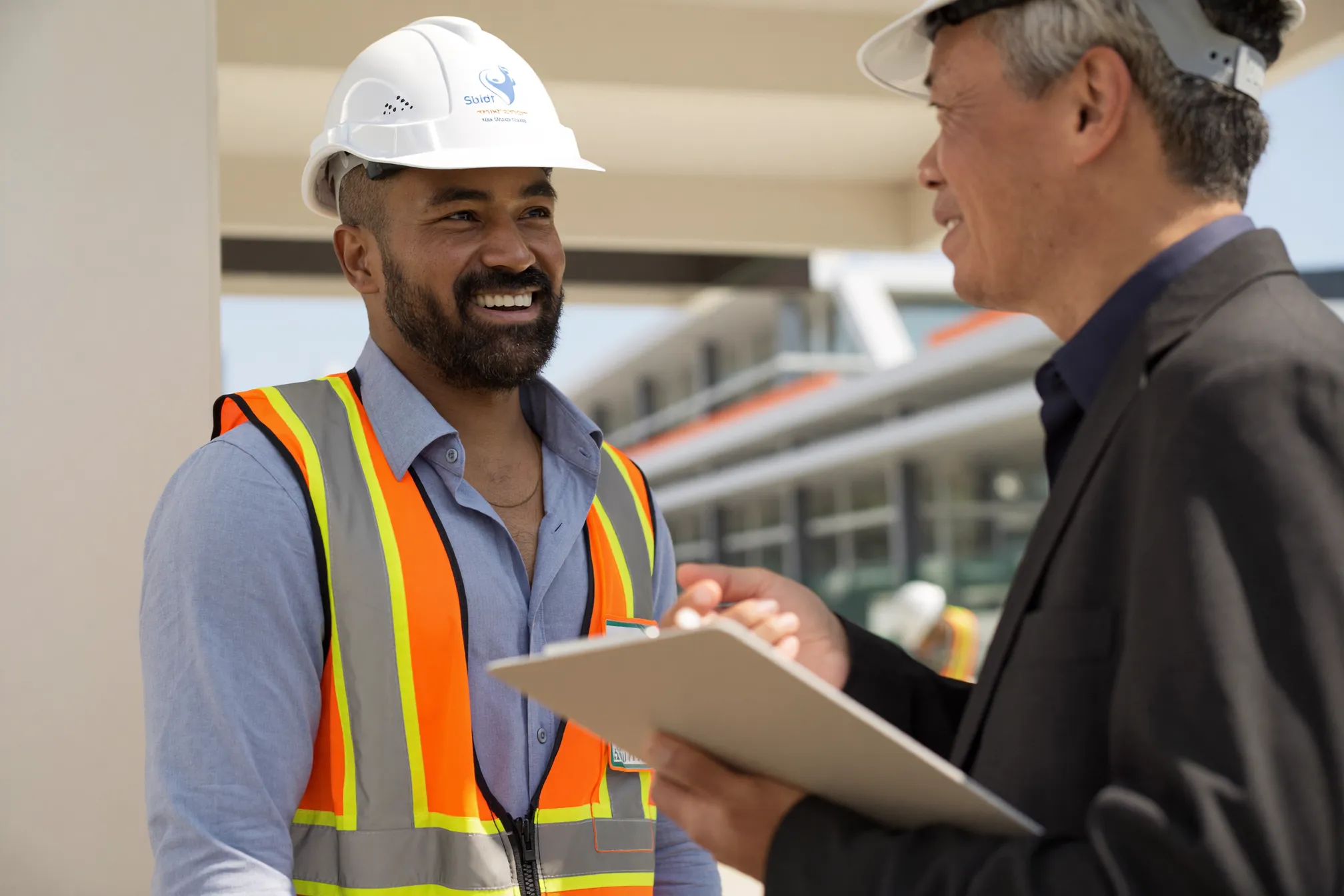 A migrant worker talking confidently with his supervisor at a Singapore worksite