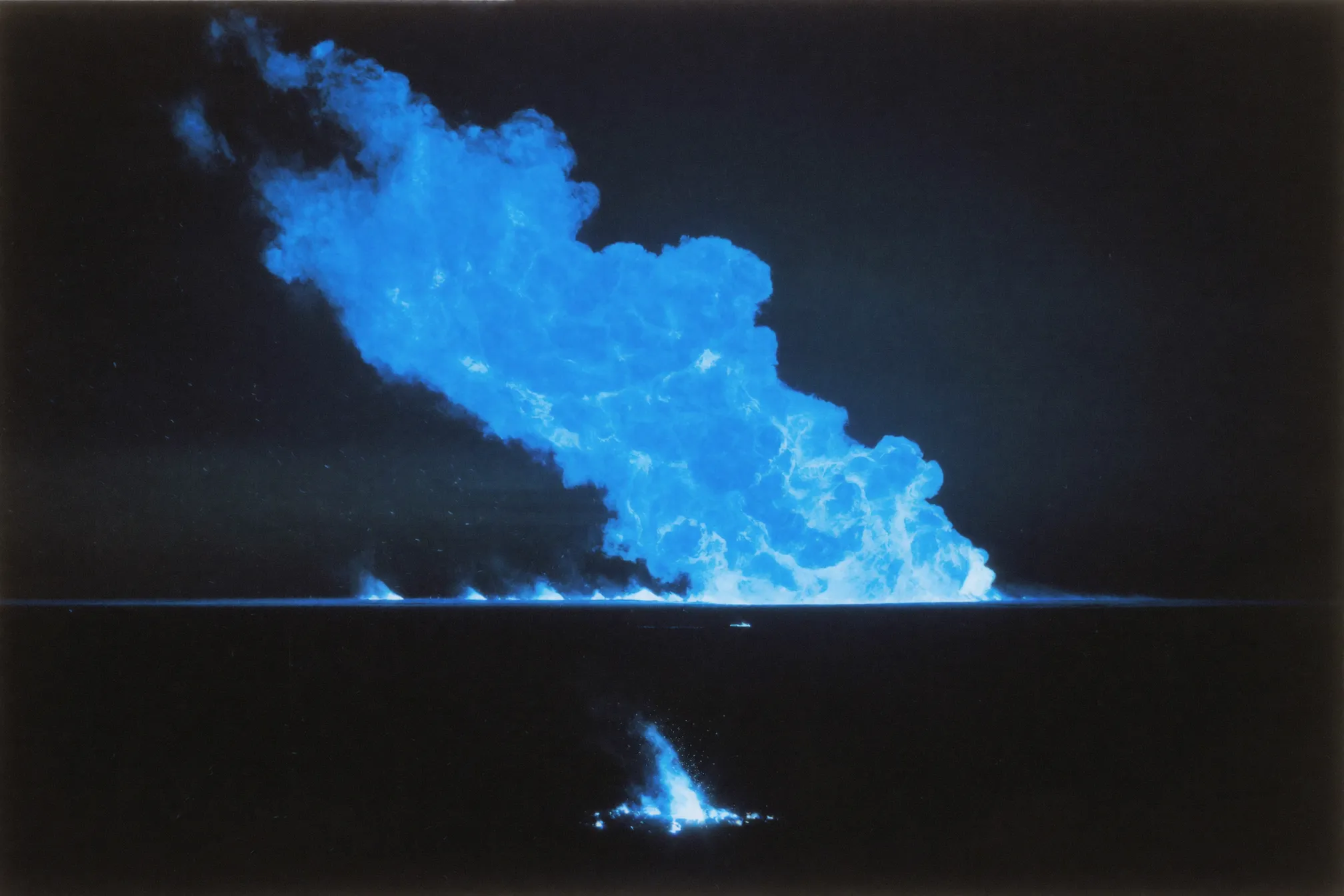 A dark plain at night with a tiny newborn blue spark in the foreground and an enormous roaring blue blaze on the horizon