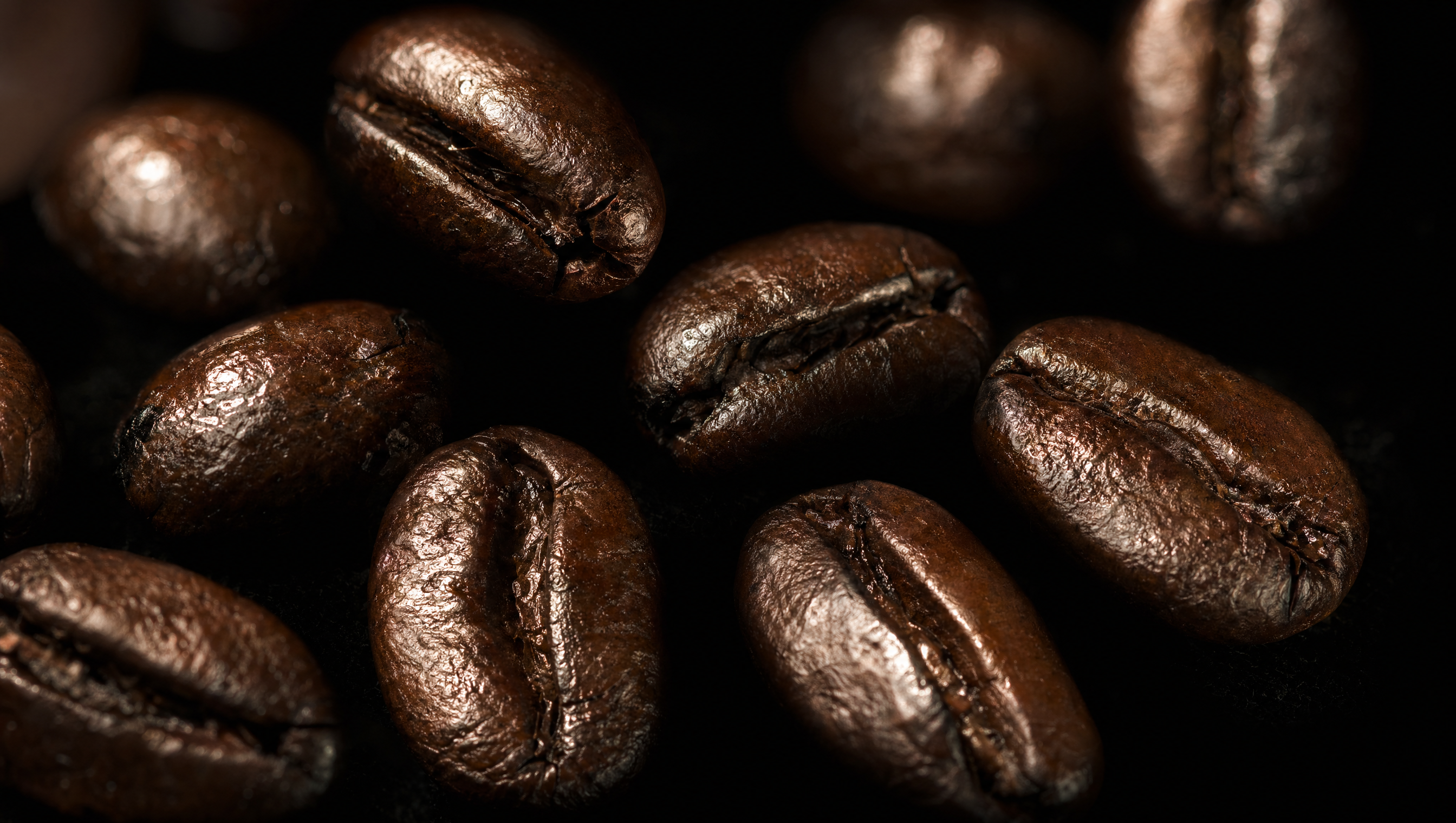 Dunkel geröstete, glänzende Espressobohnen in extremer Makroaufnahme