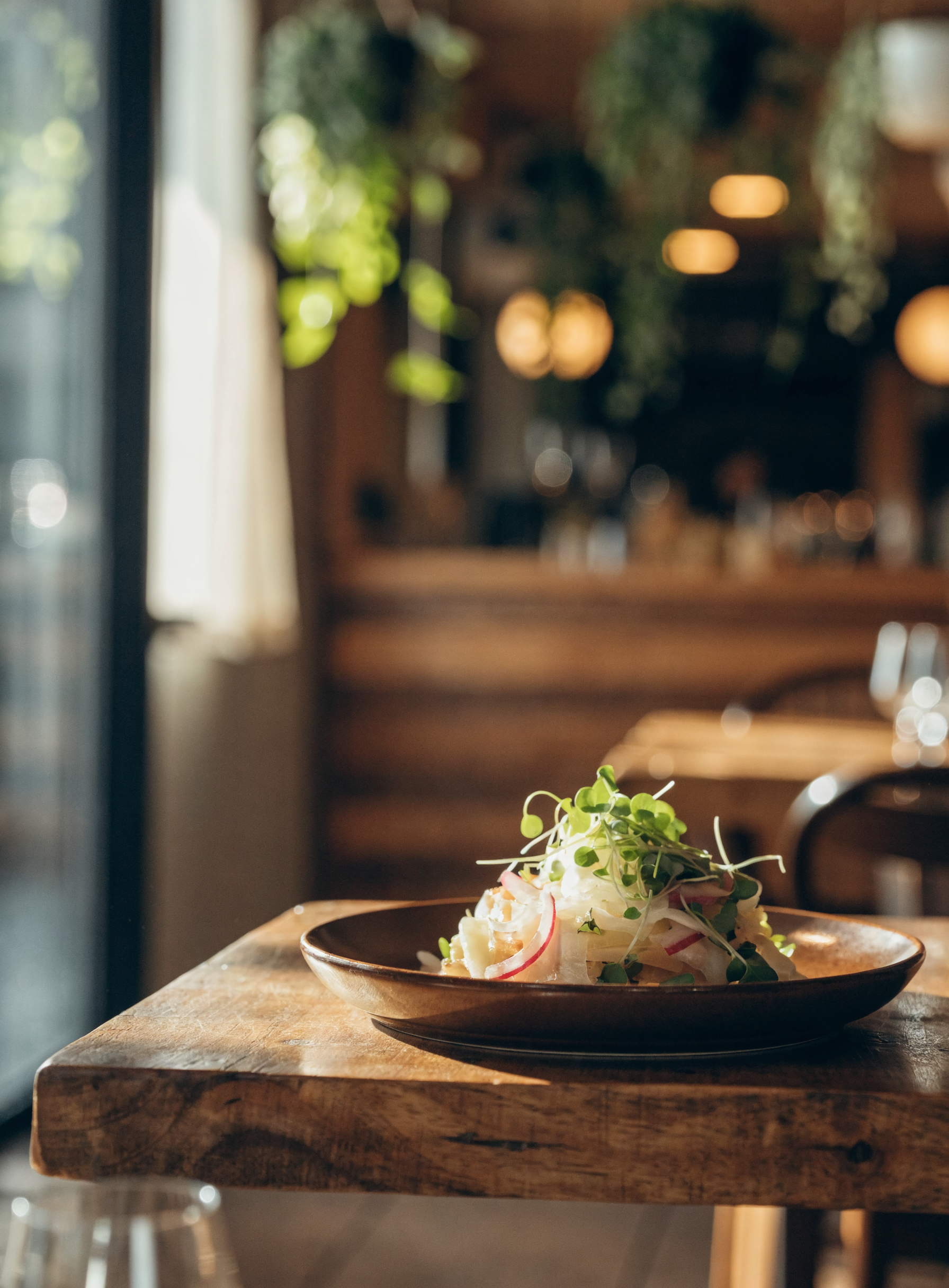 A beautifully plated dish on a wooden table in a warm restaurant interior