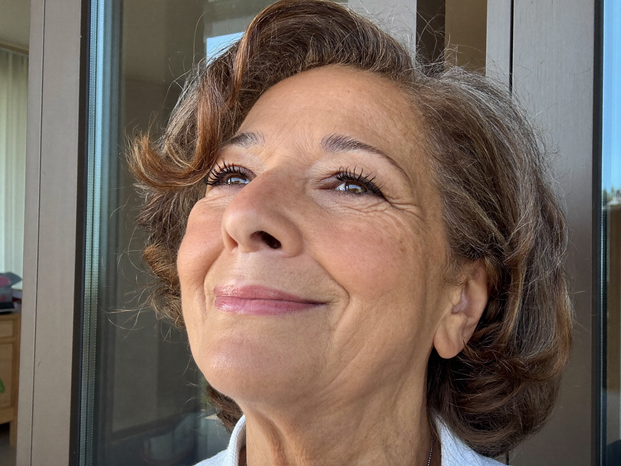 Vrouw met volle gekrulde wimpers, zelfverzekerd