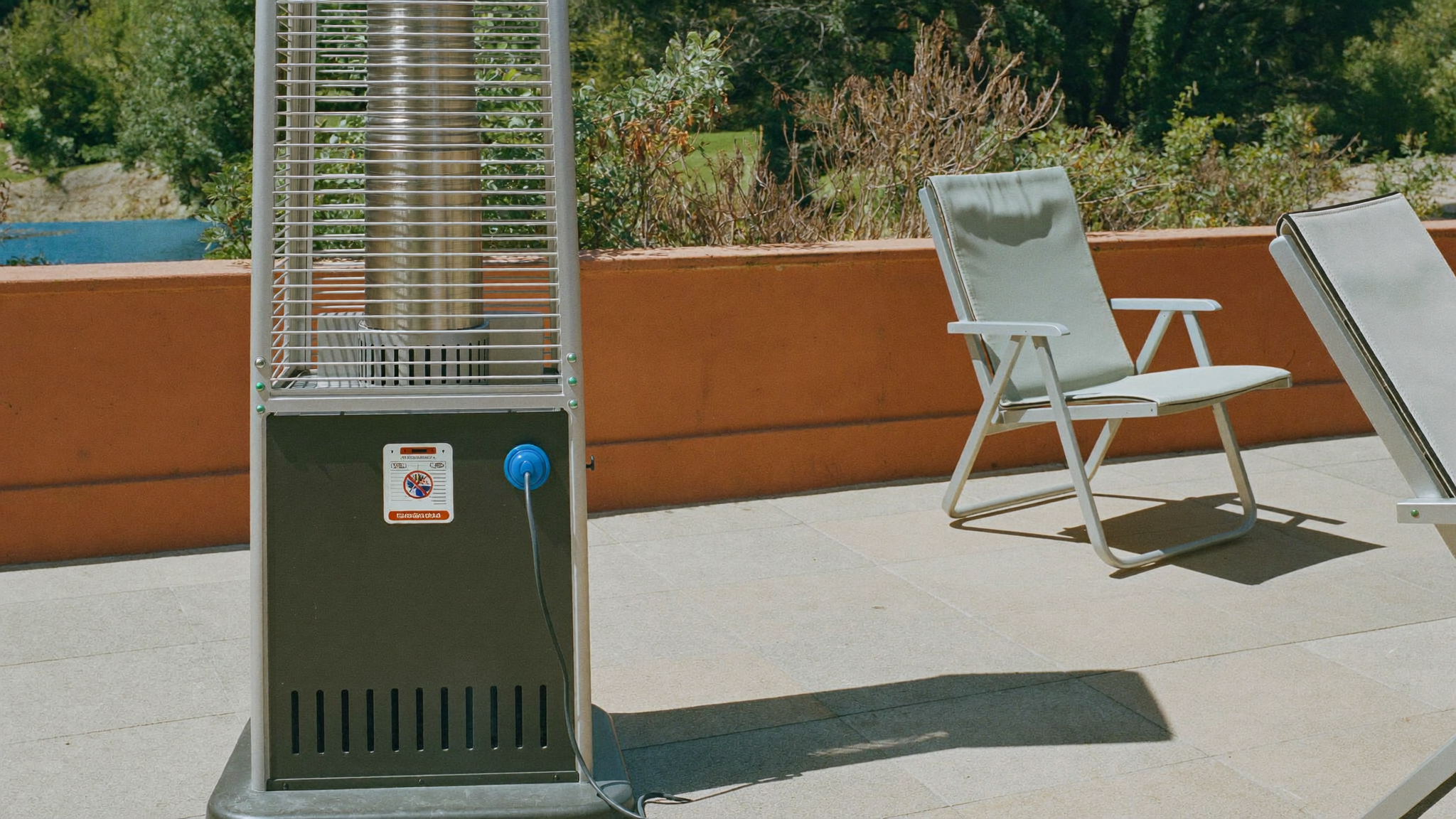 En terrassevarmer står ubrugt på en solbeskinnet terrasse