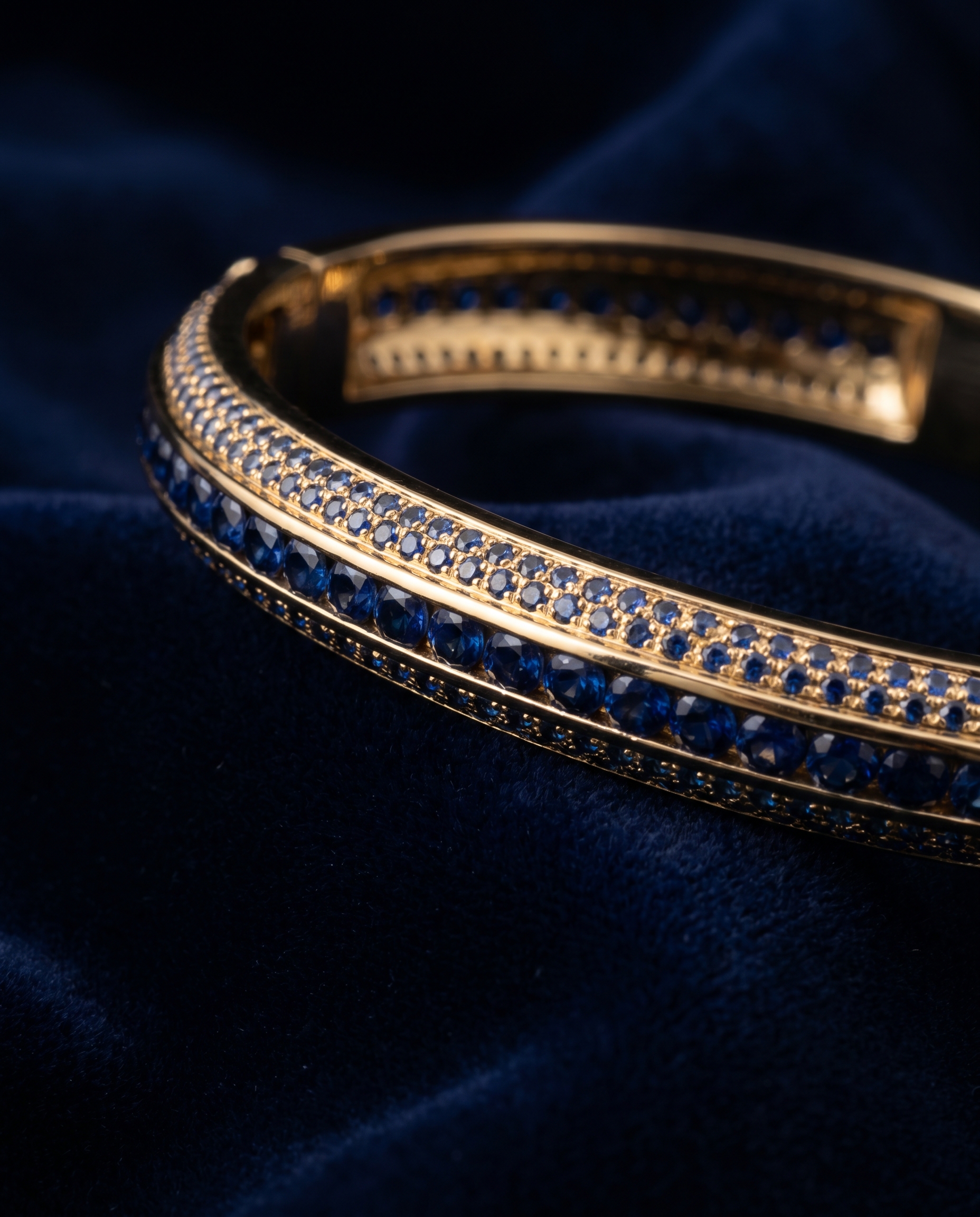 Gold bangle bracelet with sapphire accents