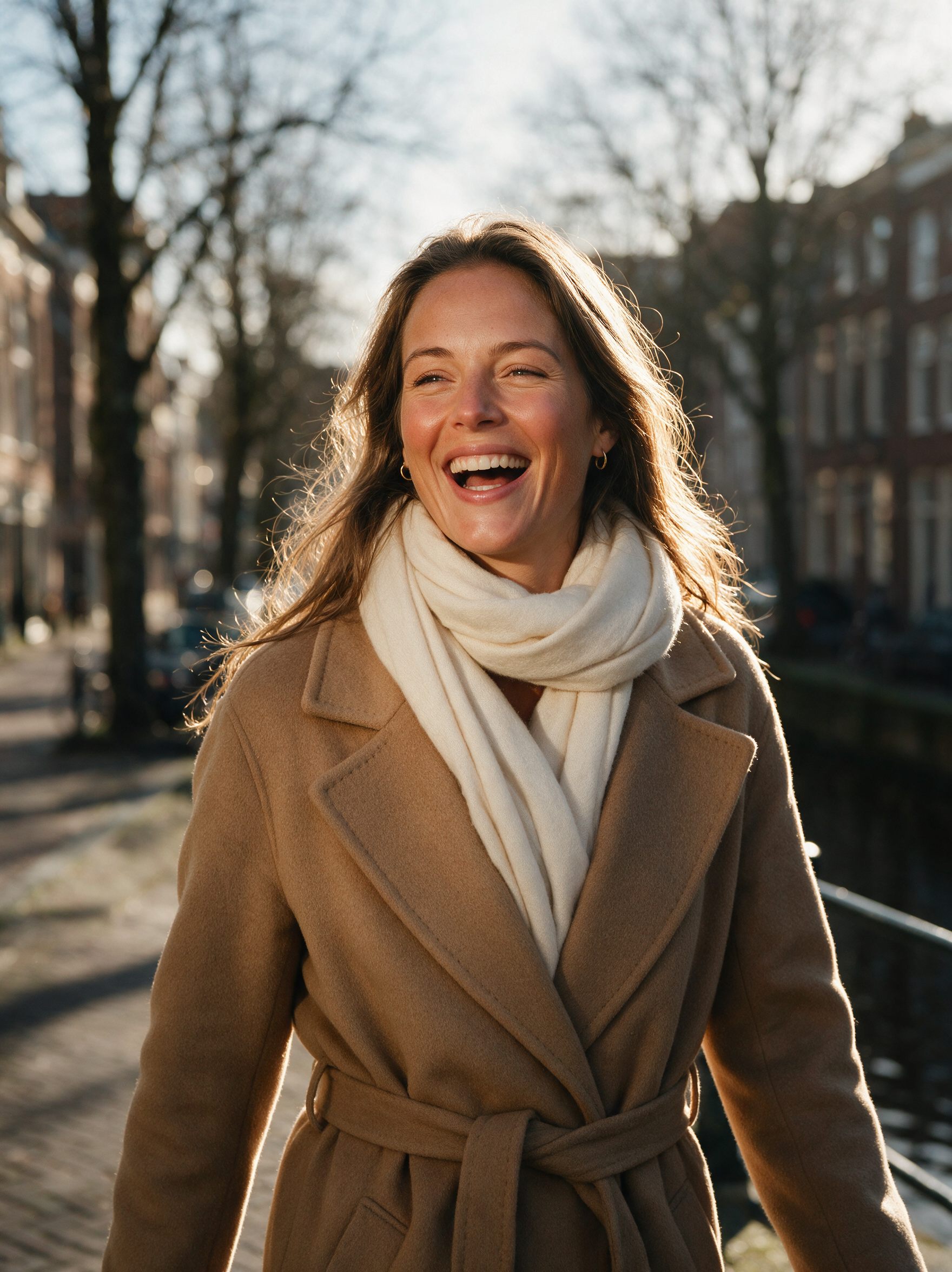 Vrouw in kamelen wollen jas buiten in de winterzon met een warme, gezonde huidtint