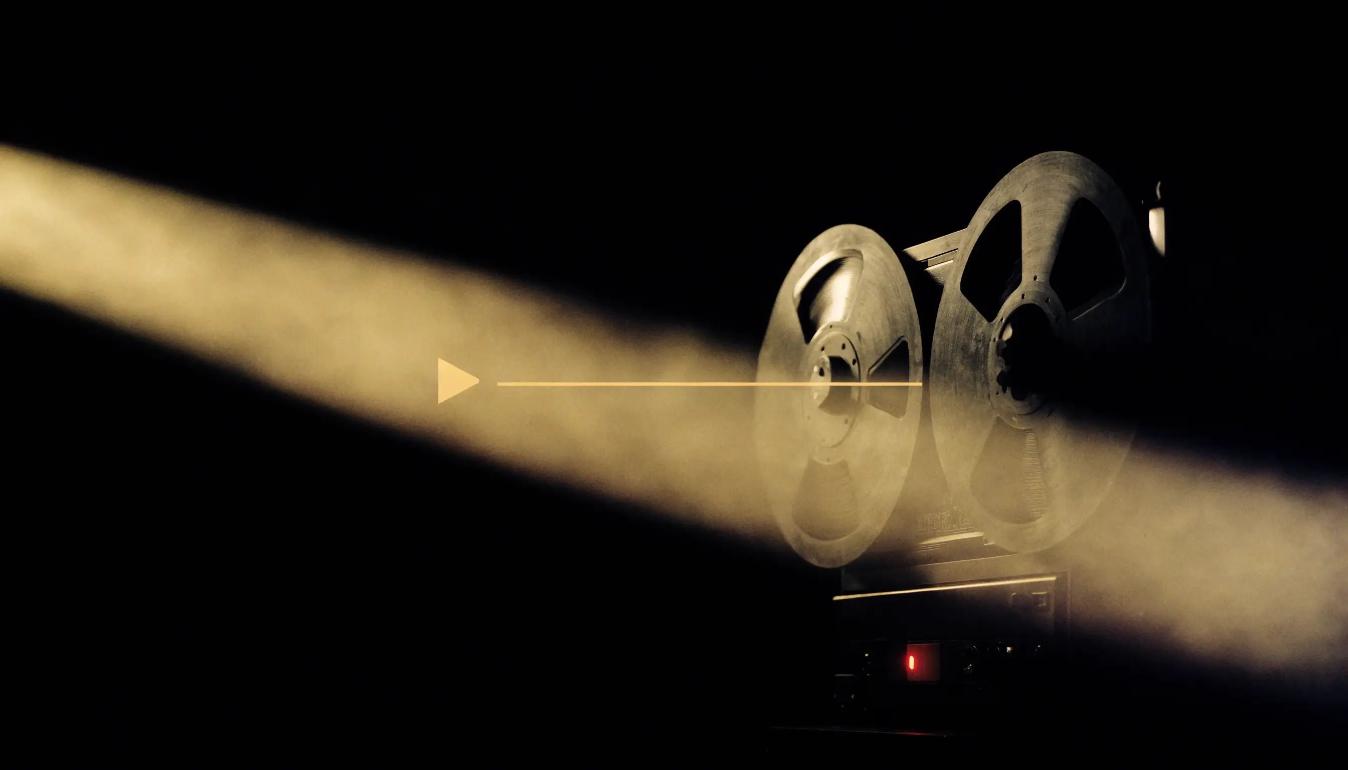 Natureza-morta editorial em fundo preto: um gravador de rolo vintage com luz vermelha de gravação ao lado de uma linha do tempo de vídeo dourada e brilhante com ícone de play, luz dourada cinematográfica cruzando o quadro