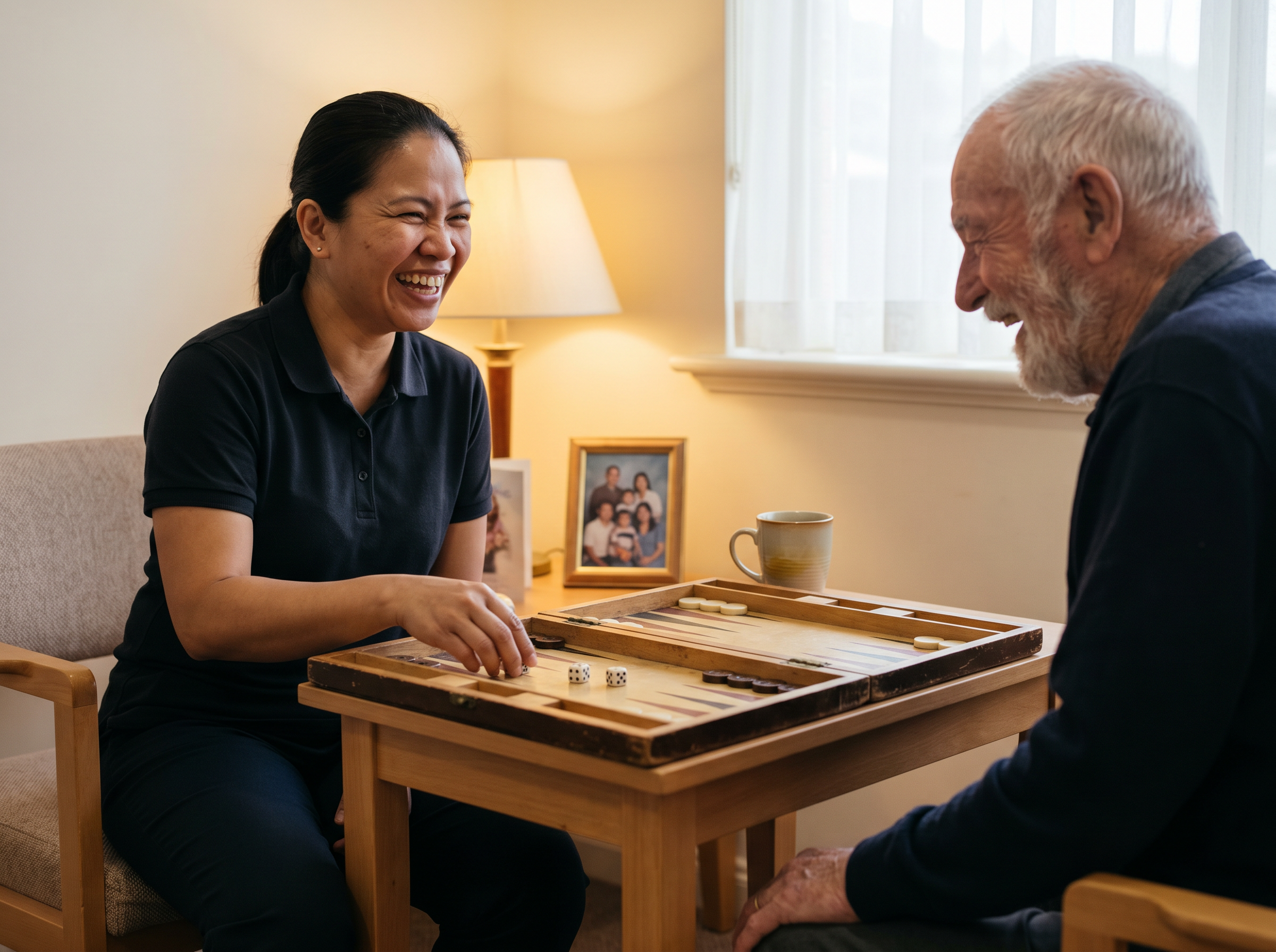 A Groworx careworker and an aged-care resident sharing a game and a laugh over a table