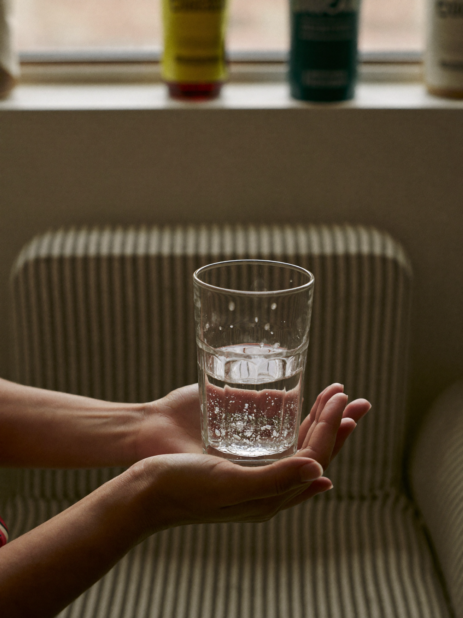 Hands holding glass of water