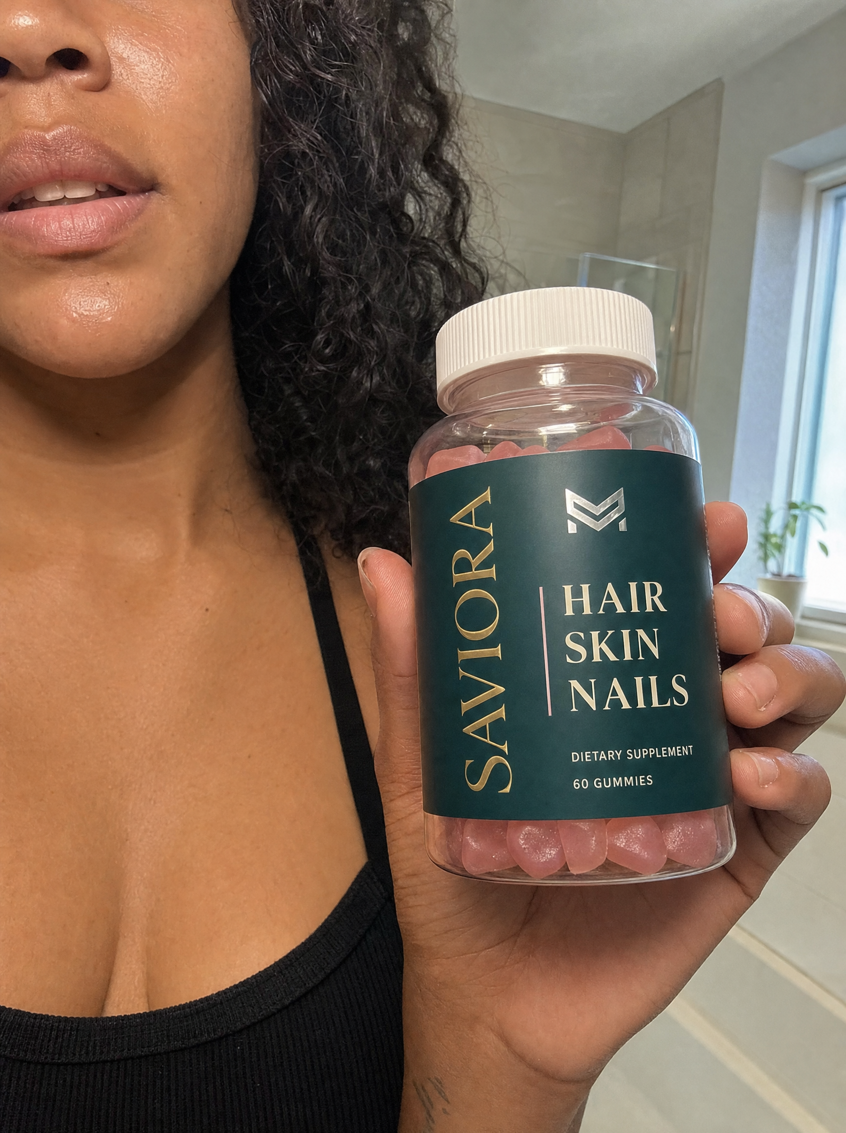 Woman holding Saviora Hair.Skin.Nails gummies bottle