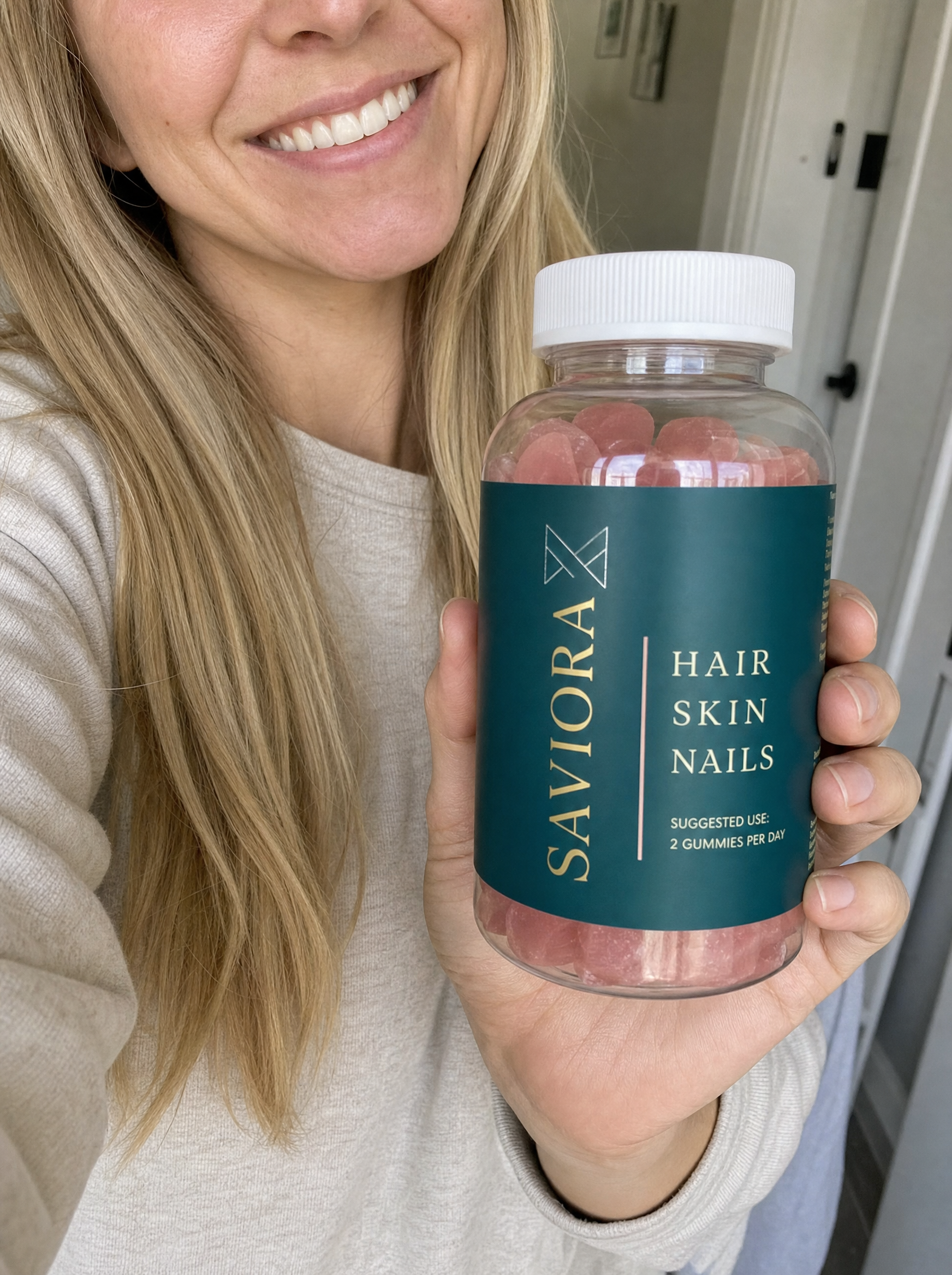 Woman holding Saviora Hair.Skin.Nails bottle