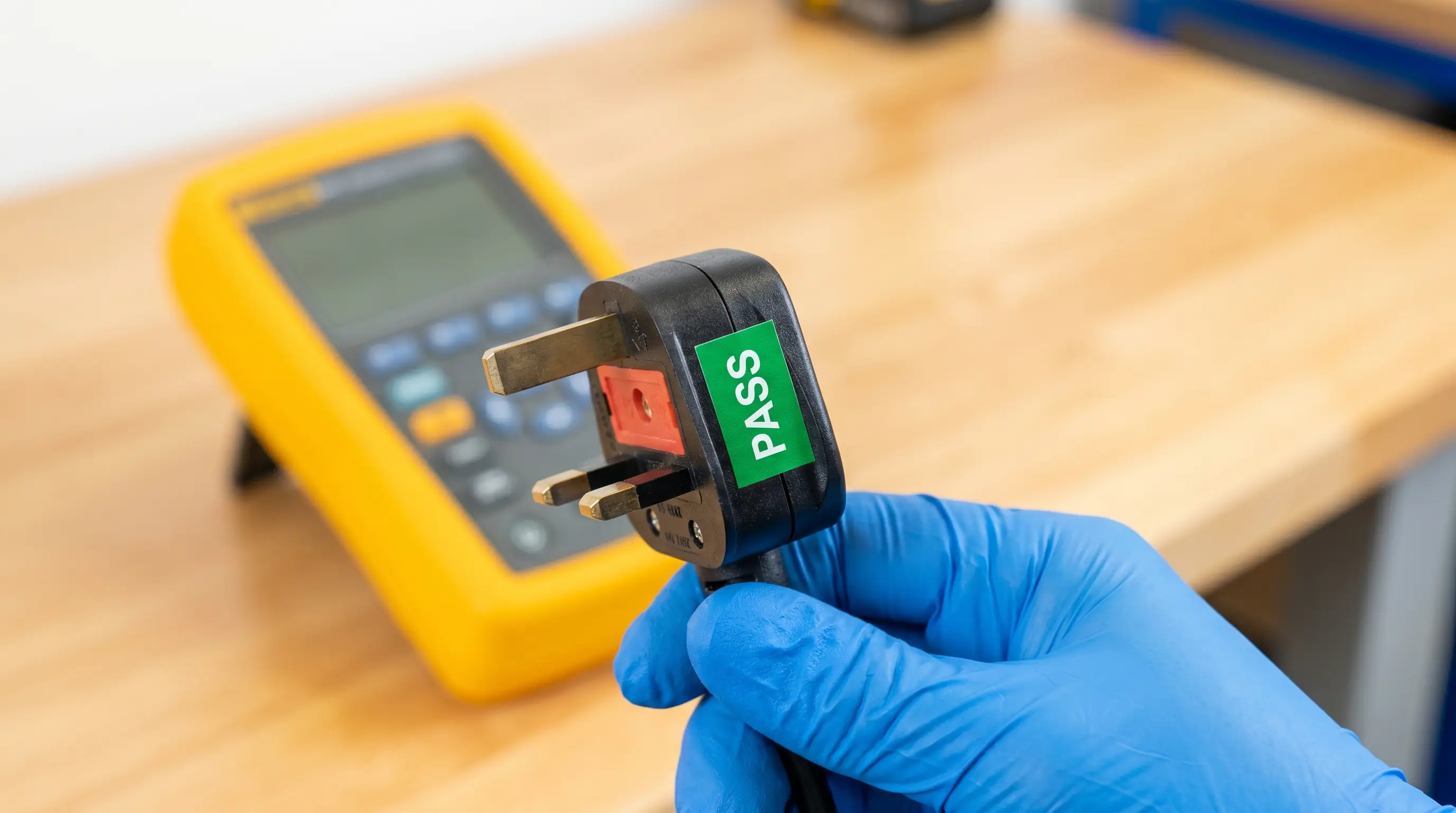 A UK plug being PAT tested with a green pass sticker applied