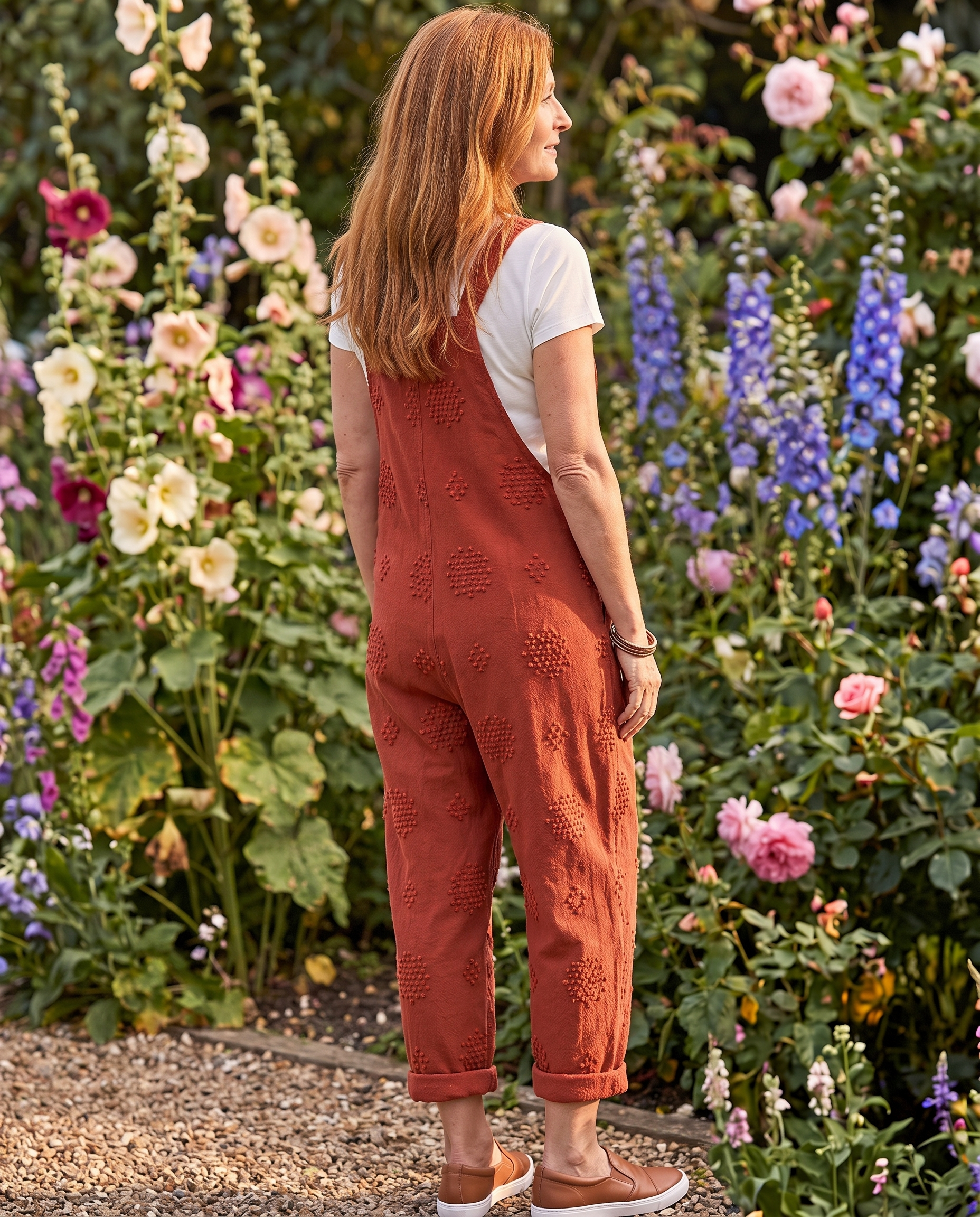 Flora Brick Red Jumpsuit worn on a garden path