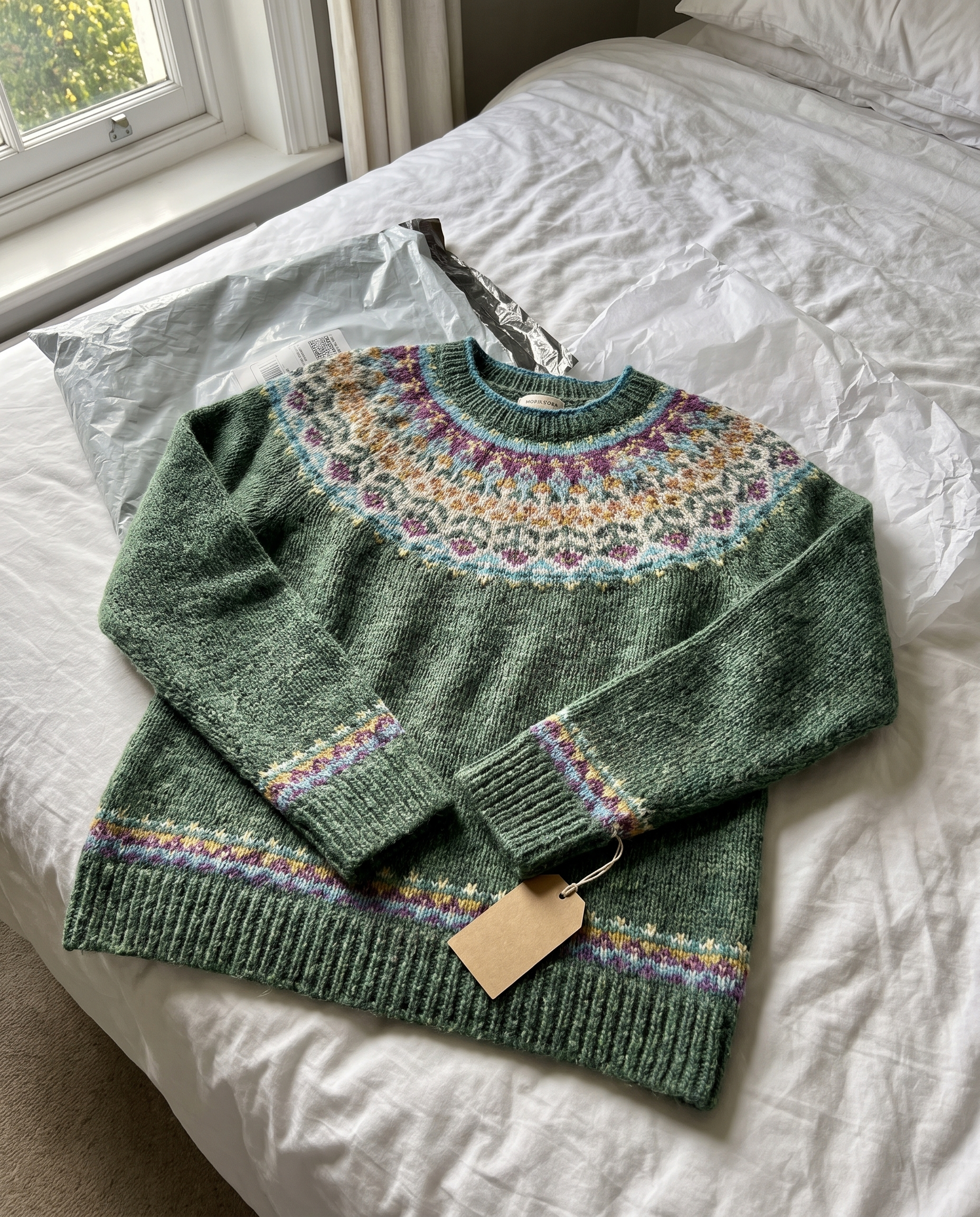 Ursula Classic Icelandic Knit Sweater just unpacked on a bed with its tag still attached