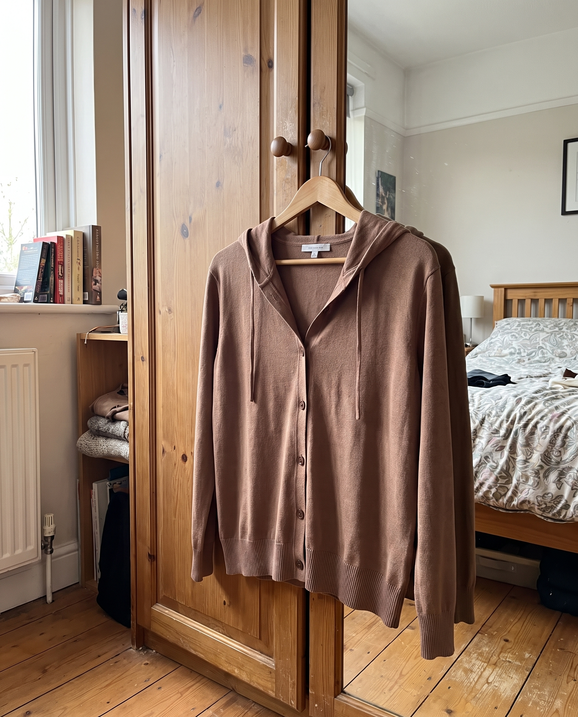 Nora Cappuccino Hooded Cardigan hanging on a wooden hanger