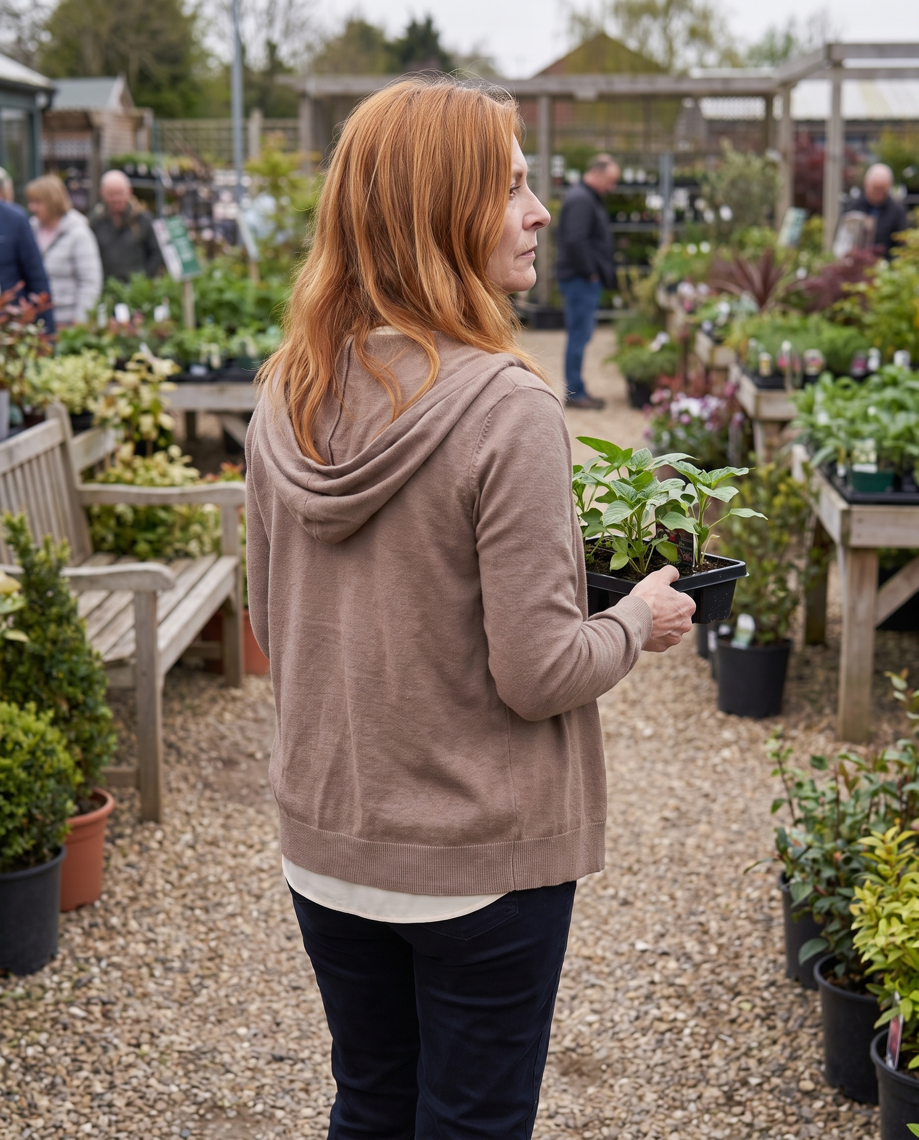 Diane Ashcroft wearing the Nora Cappuccino Hooded Cardigan at a garden centre, seen from behind