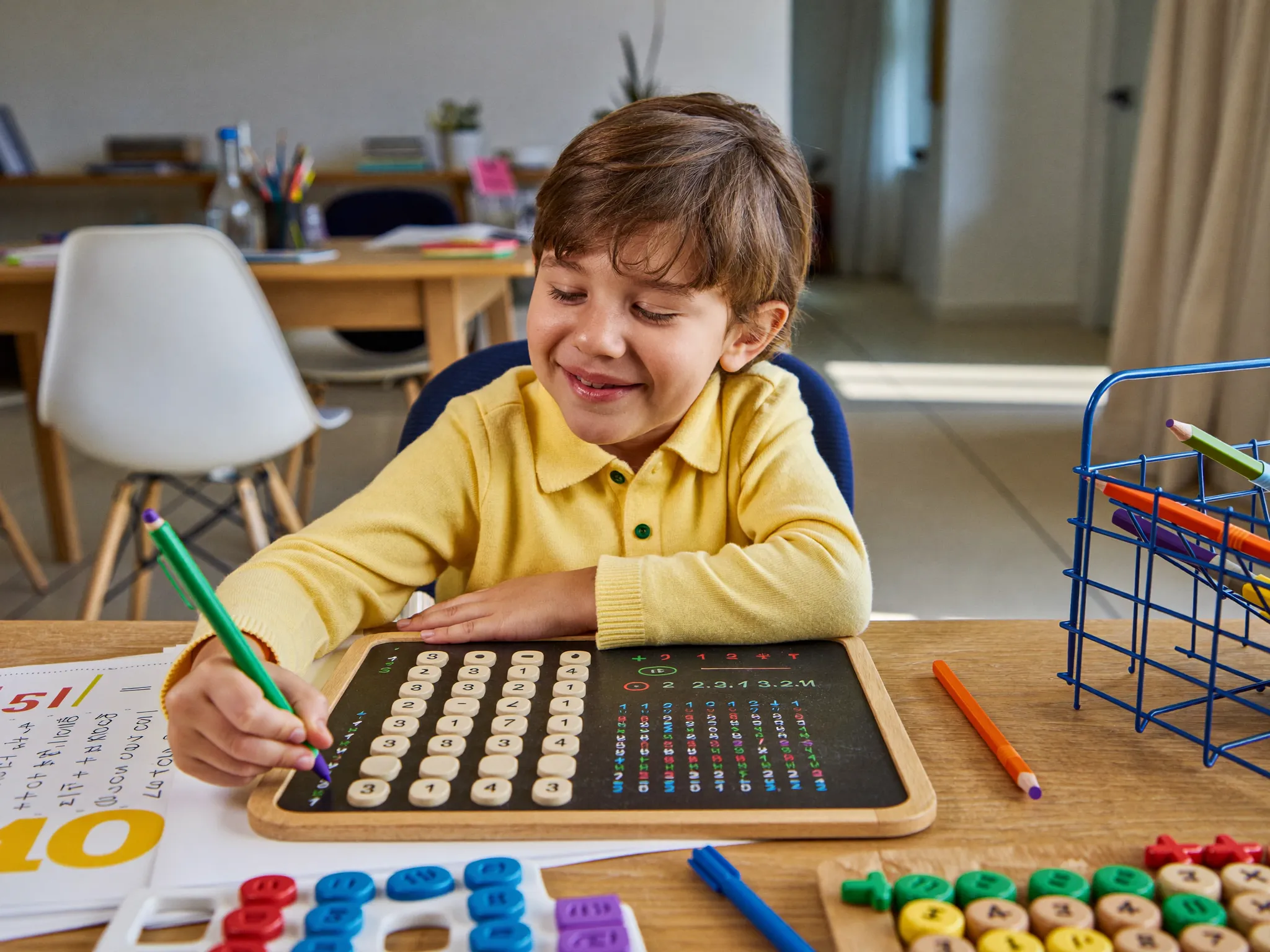 A primary-age child practising Maths with a whiteboard