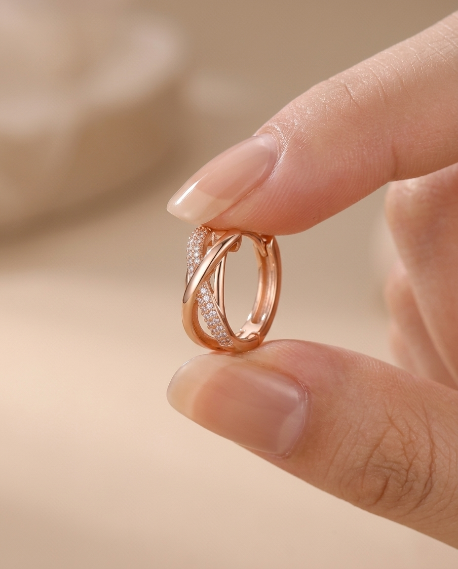 Roze gold ukrštena minđuša među prstima, prikaz prave veličine