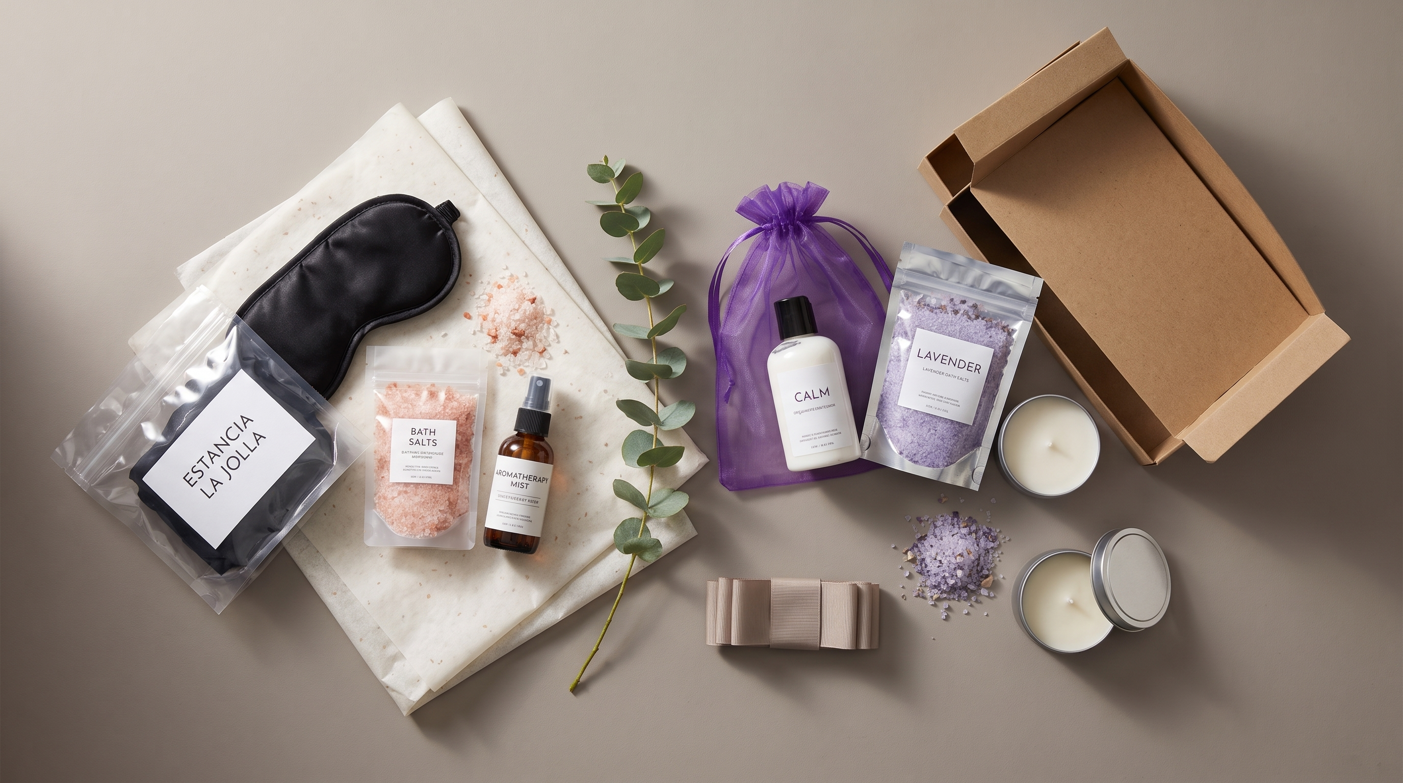 Wholesale bath and spa gift sets featuring candles, bath salts, and soap bars in custom kraft gift box packaging with tissue paper, styled flat lay for corporate gifting