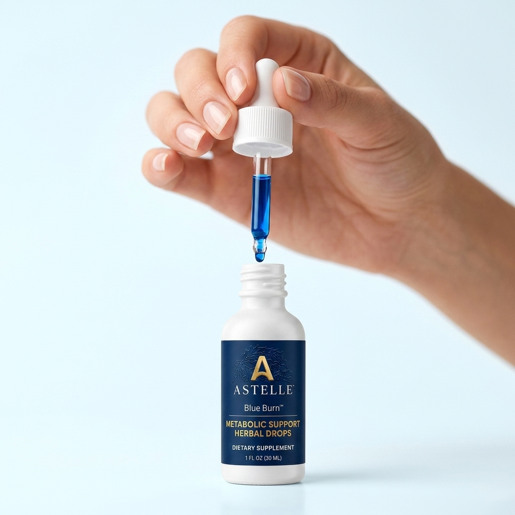 Hand squeezing the Astelle dropper above the open bottle, blue liquid visible in the pipette