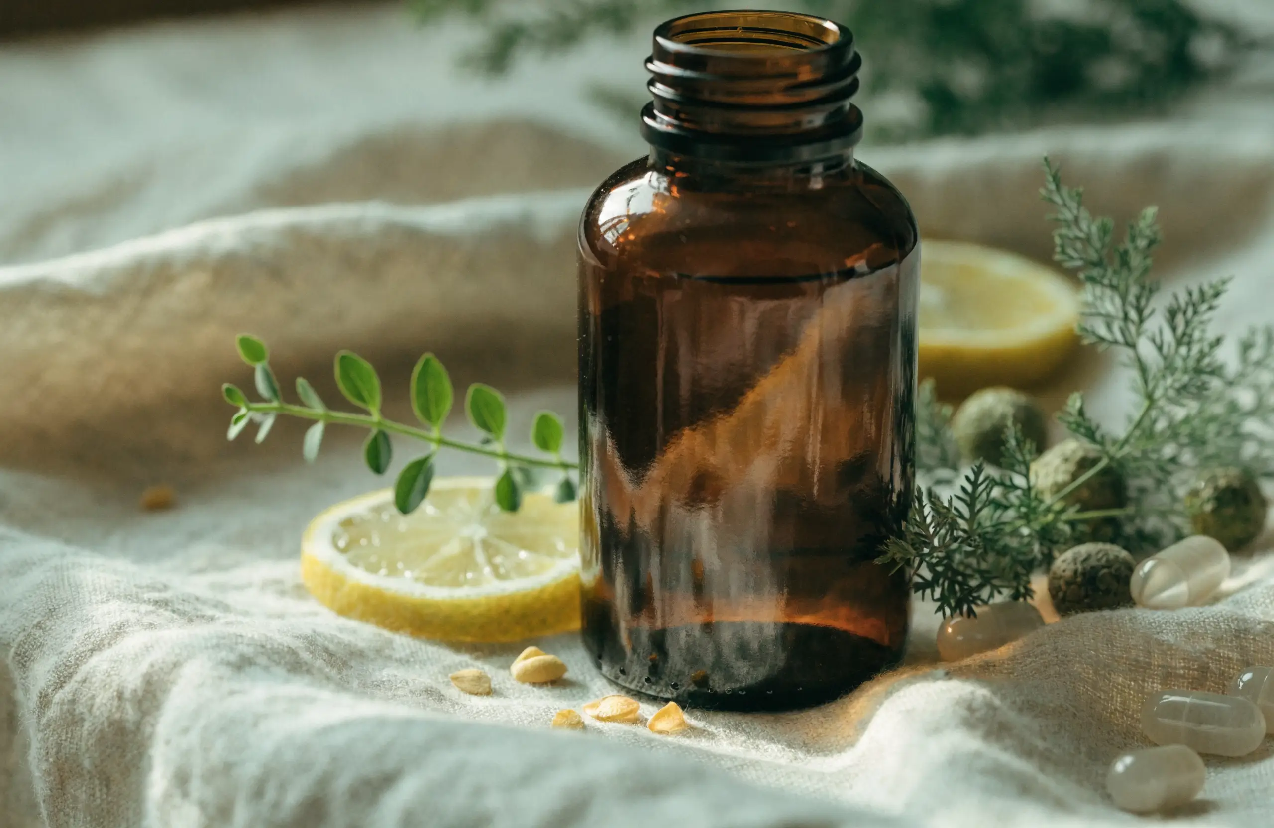 An unlabeled amber supplement bottle surrounded by fresh botanical ingredients on warm linen