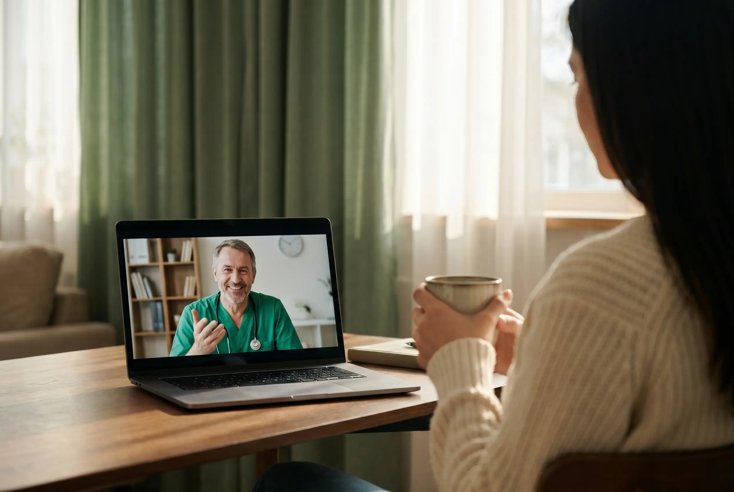 A licensed doctor on a telehealth video call, viewed from a cozy home