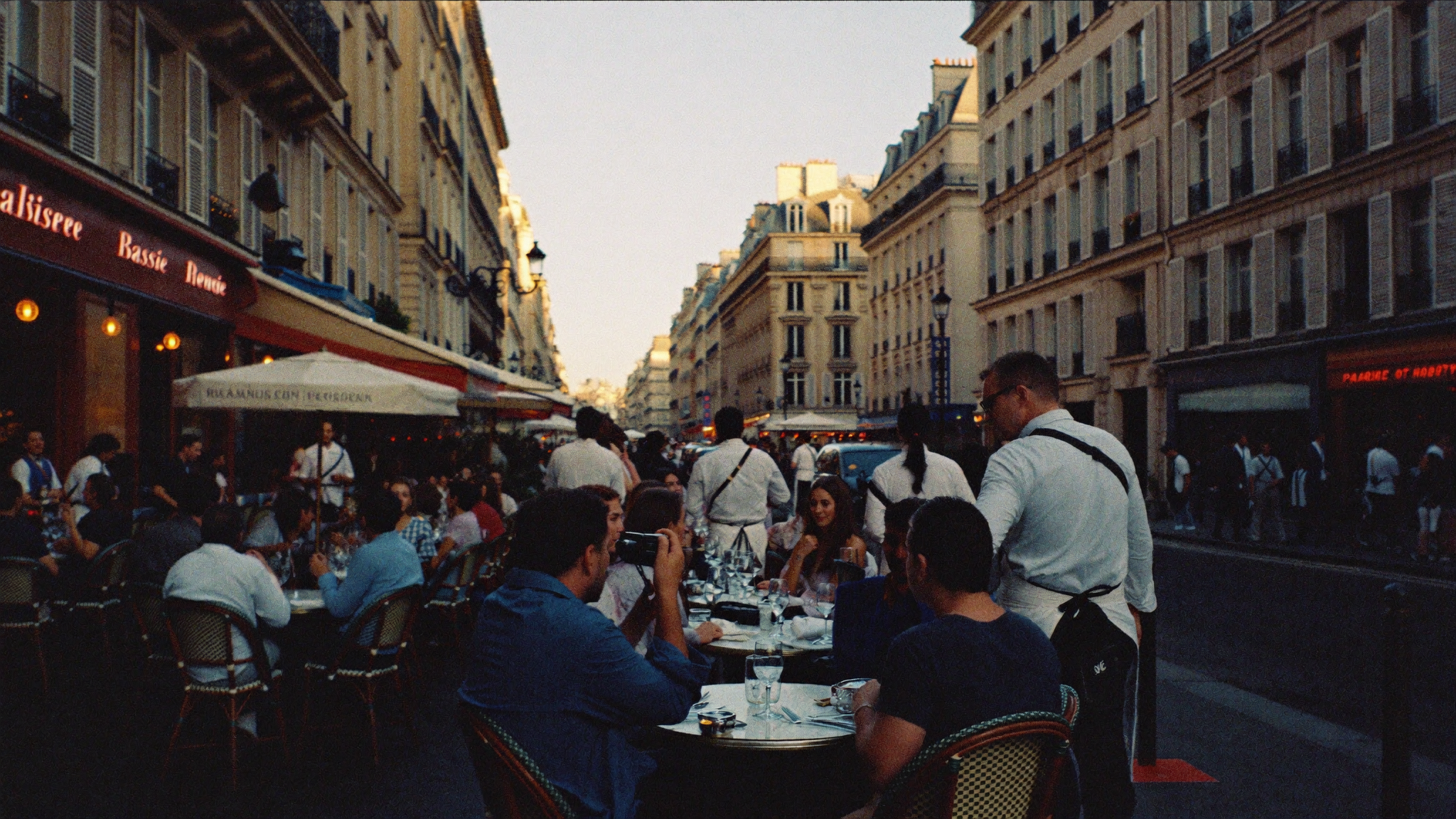 Terrasse d'une brasserie parisienne animée à l'heure dorée