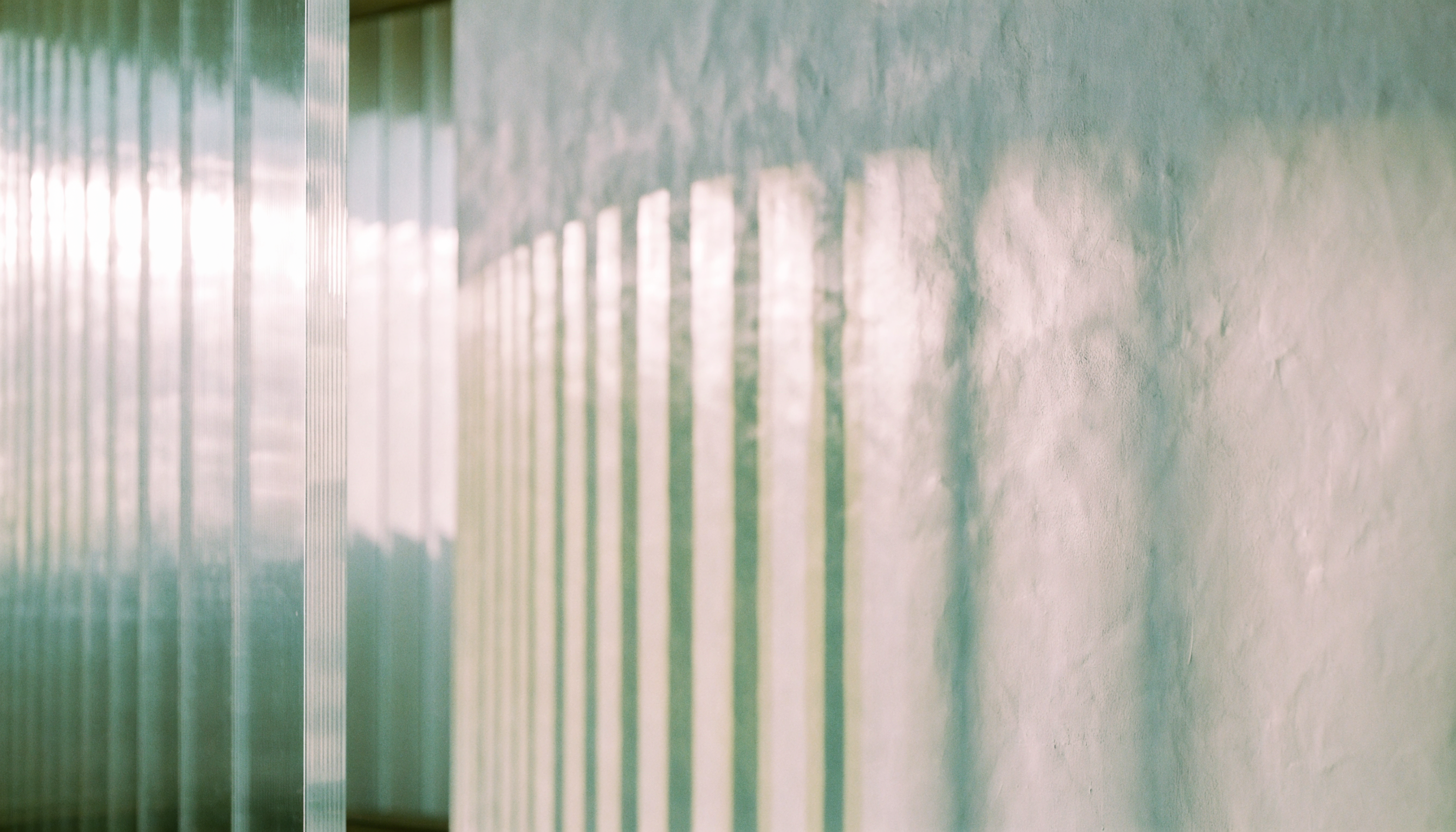 Soft daylight through fluted glass — abstract architectural photography