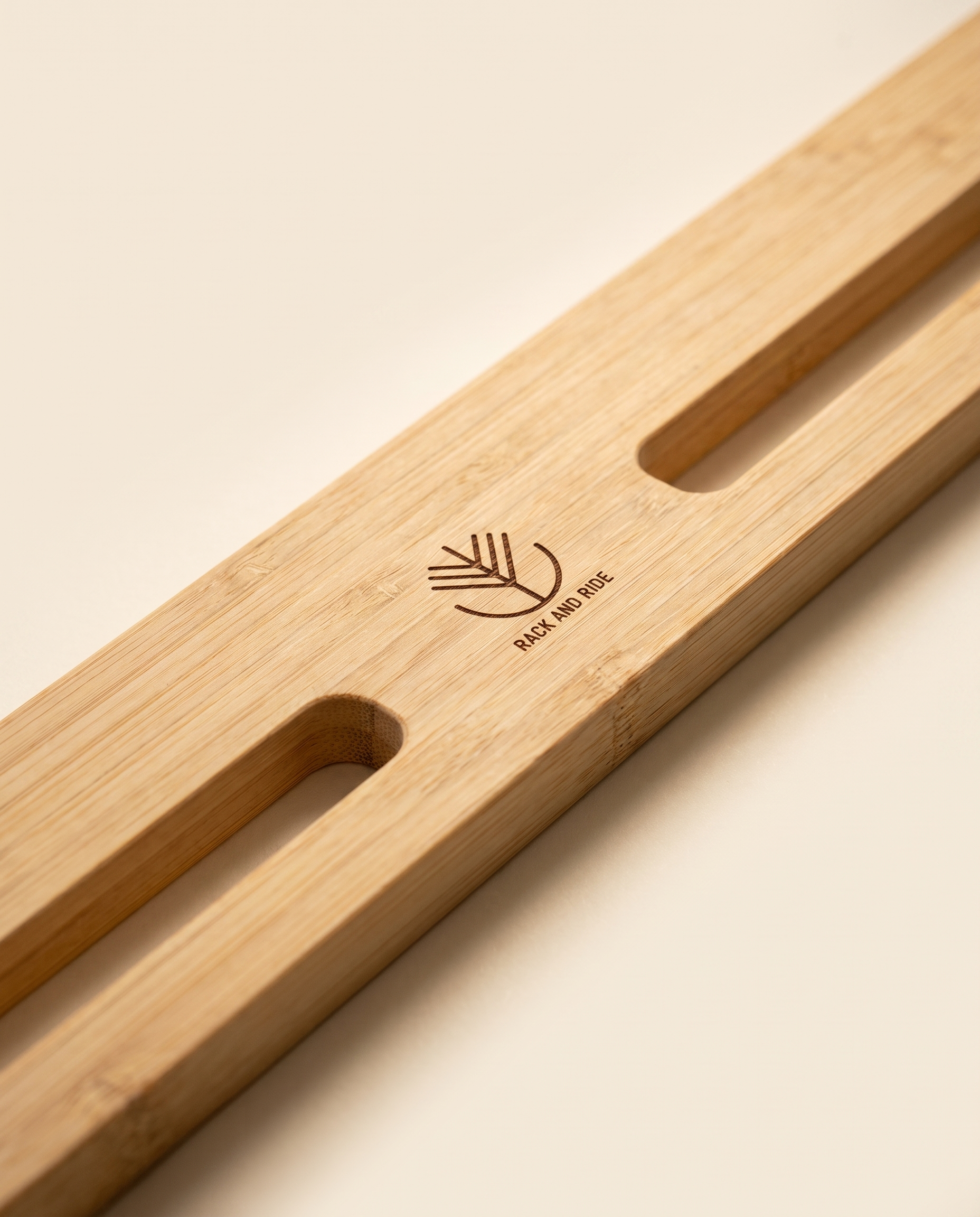 Gros plan sur le veinage du bambou et le logo gravé du support double pour skateboard