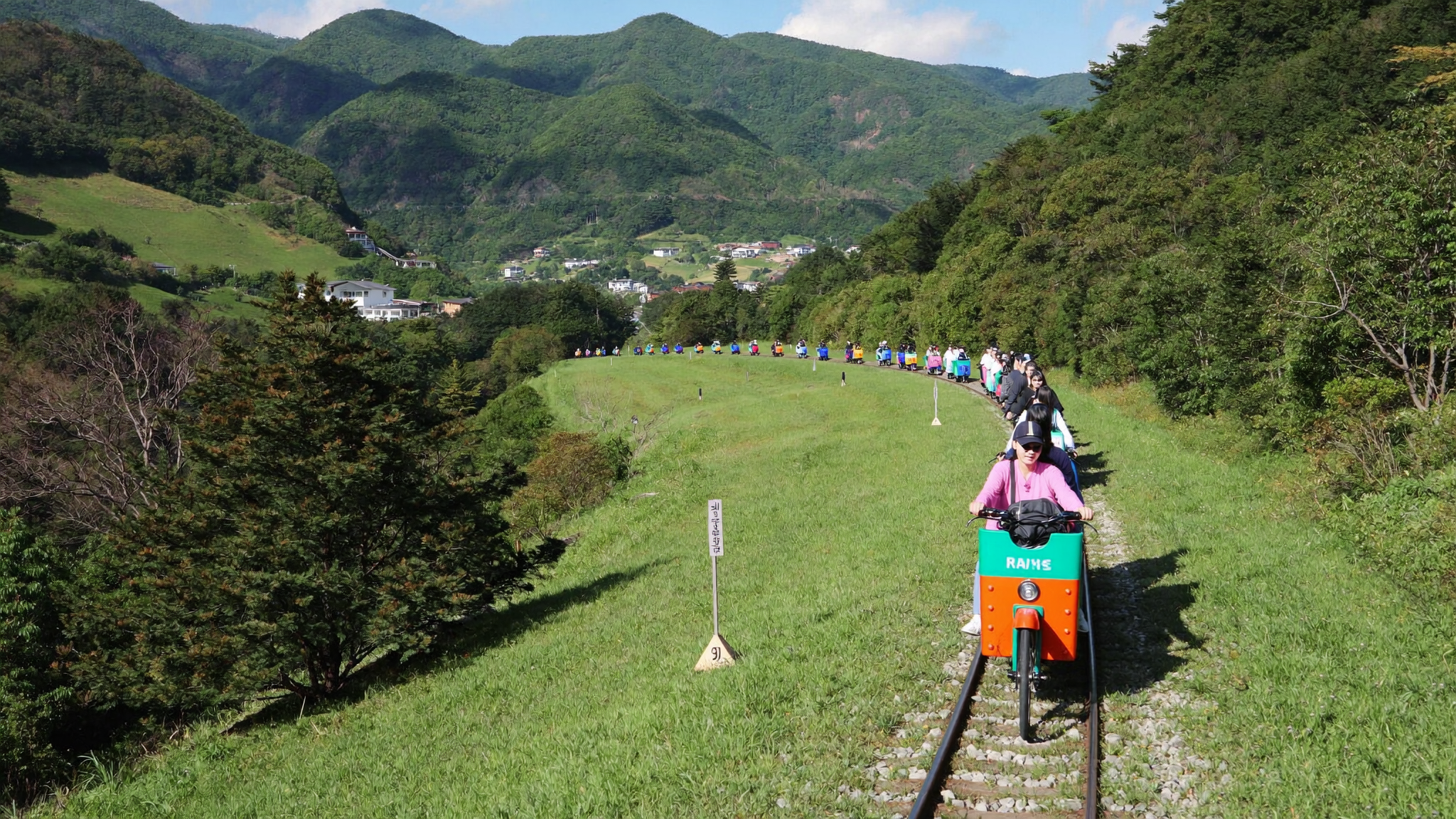 加平旅行ガイド レールバイクで田園風景を走る観光客