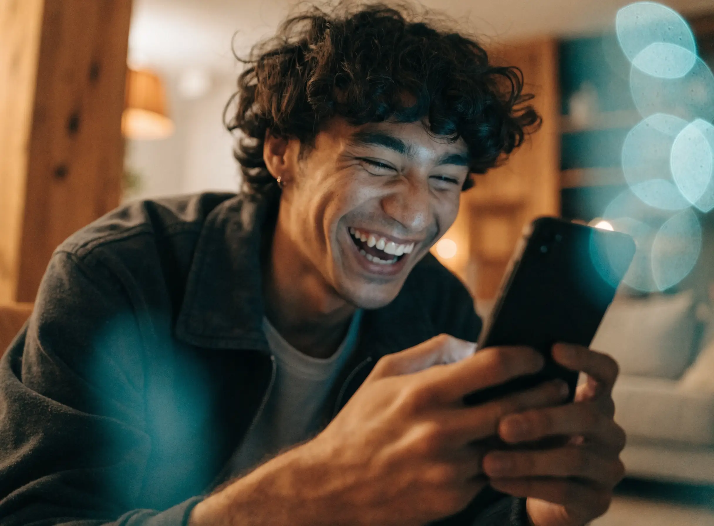 Creator laughing while livestreaming to a phone in portrait