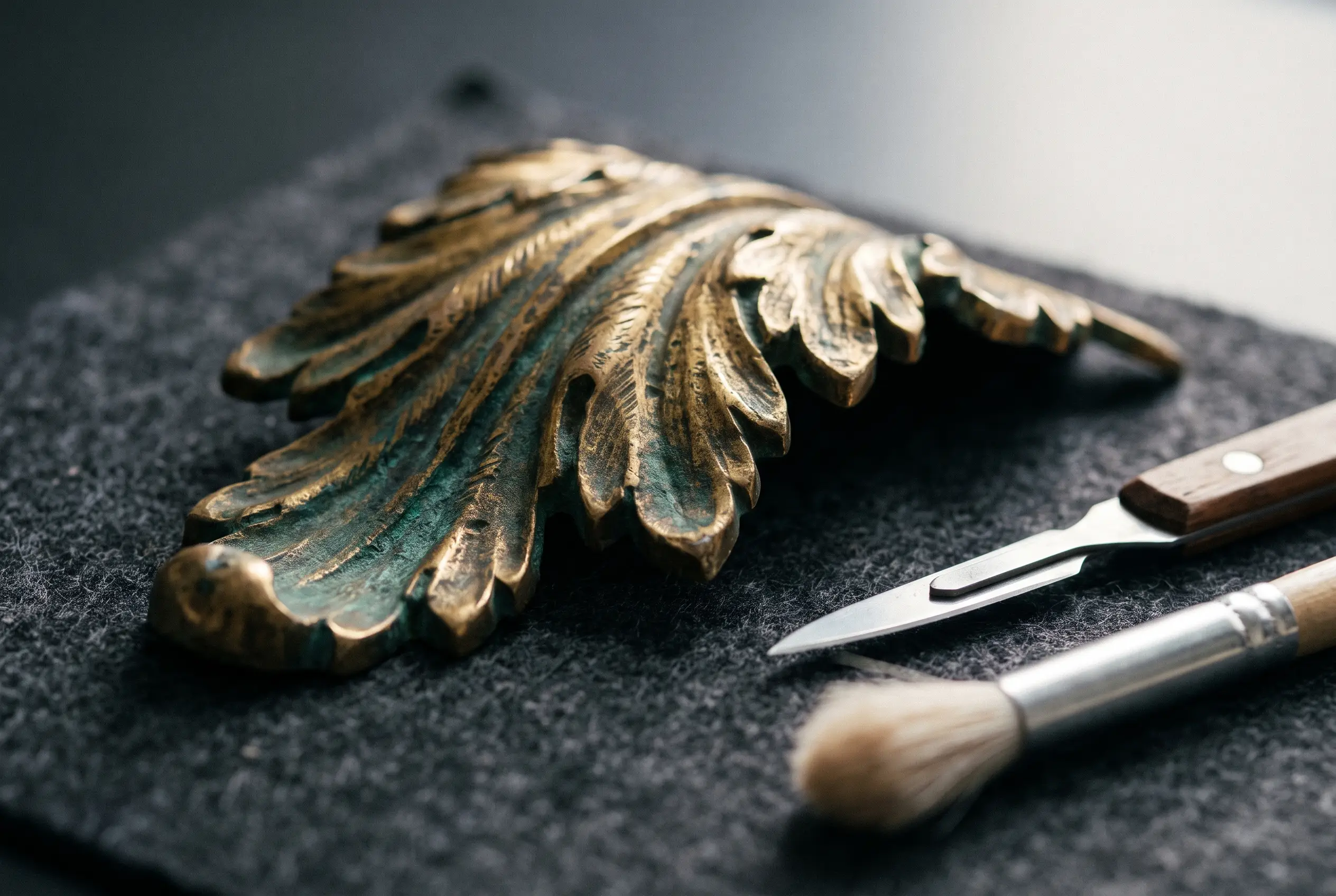 Ornement en bronze doré ciselé sous lumière rasante