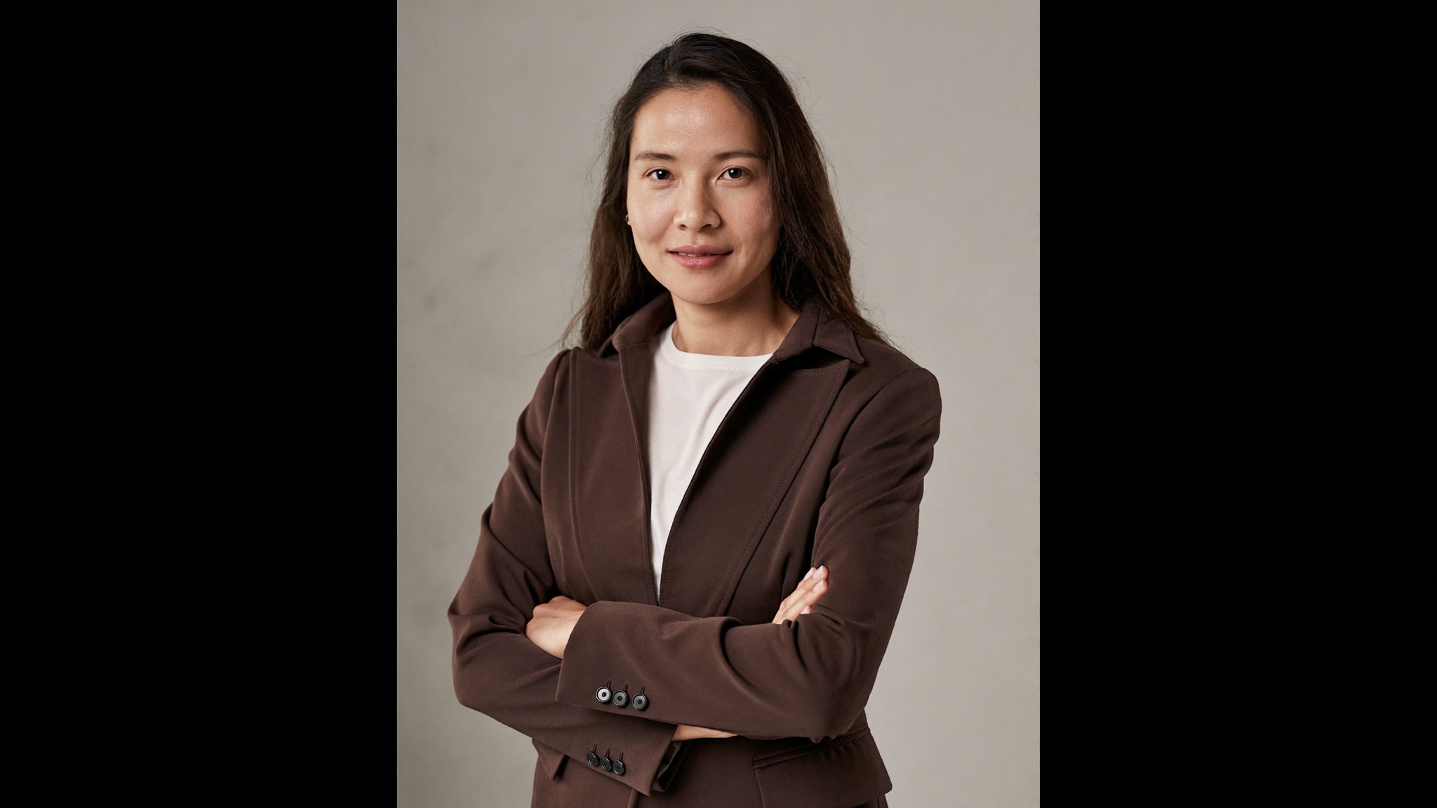 Pacific Islander businesswoman in her 30s, warm confident expression, softly lit clean neutral studio, waist-up portrait