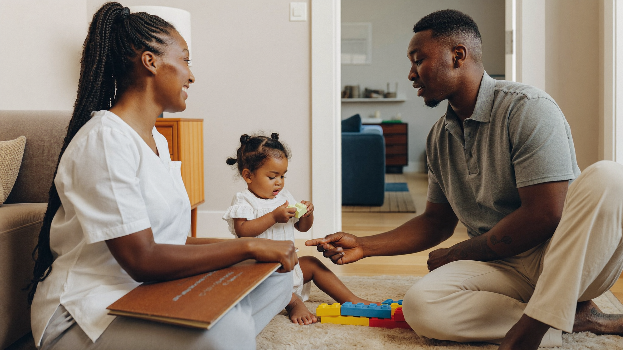 Provider and parent talking while a child plays nearby